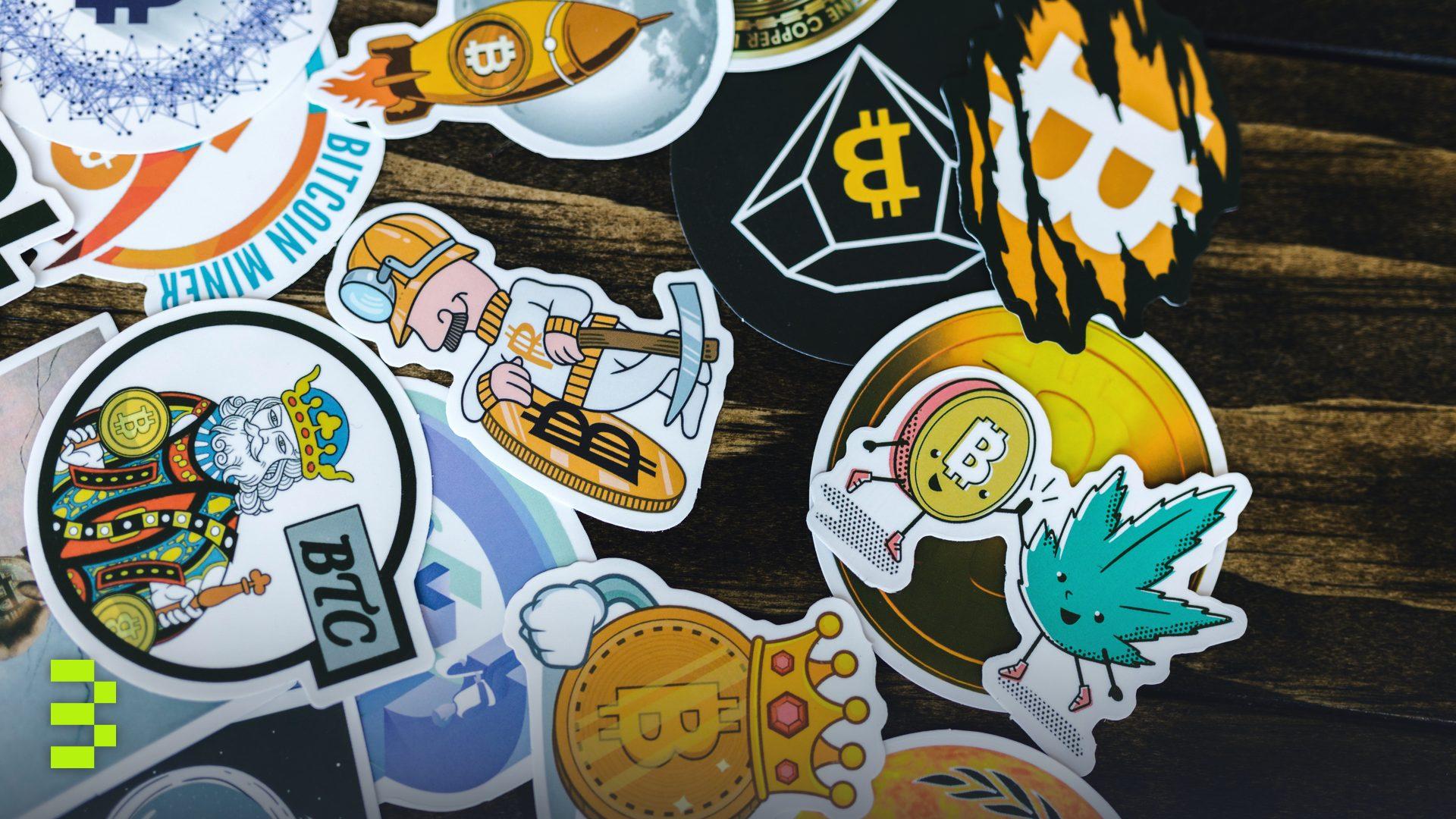 Colorful stickers featuring Bitcoin and cryptocurrency themes on a wooden surface.