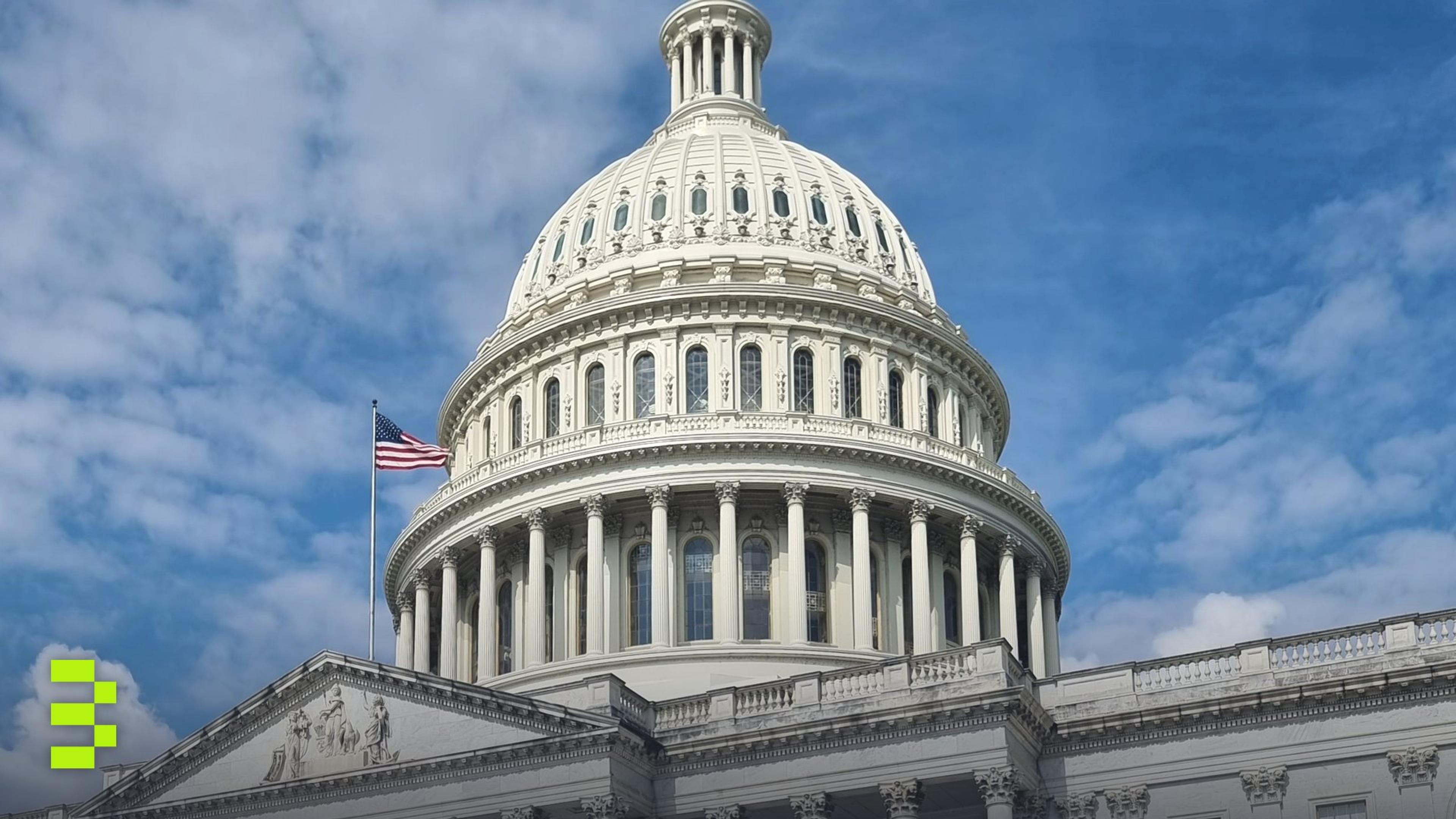A striking view of the US Capitol dome with flag and blue sky in Washington, DC.
