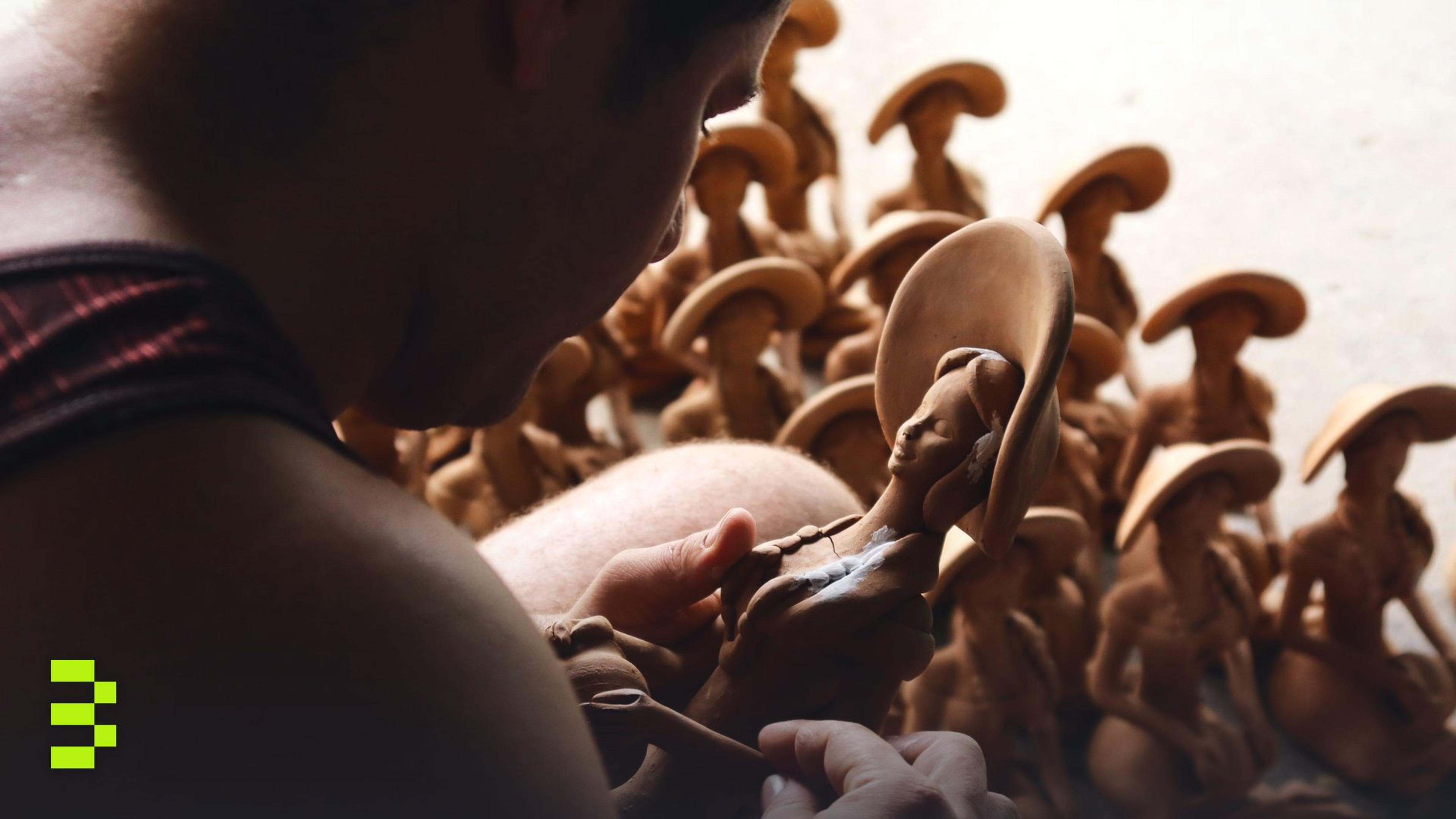 Close-up of an artisan crafting clay sculptures in a workshop setting.