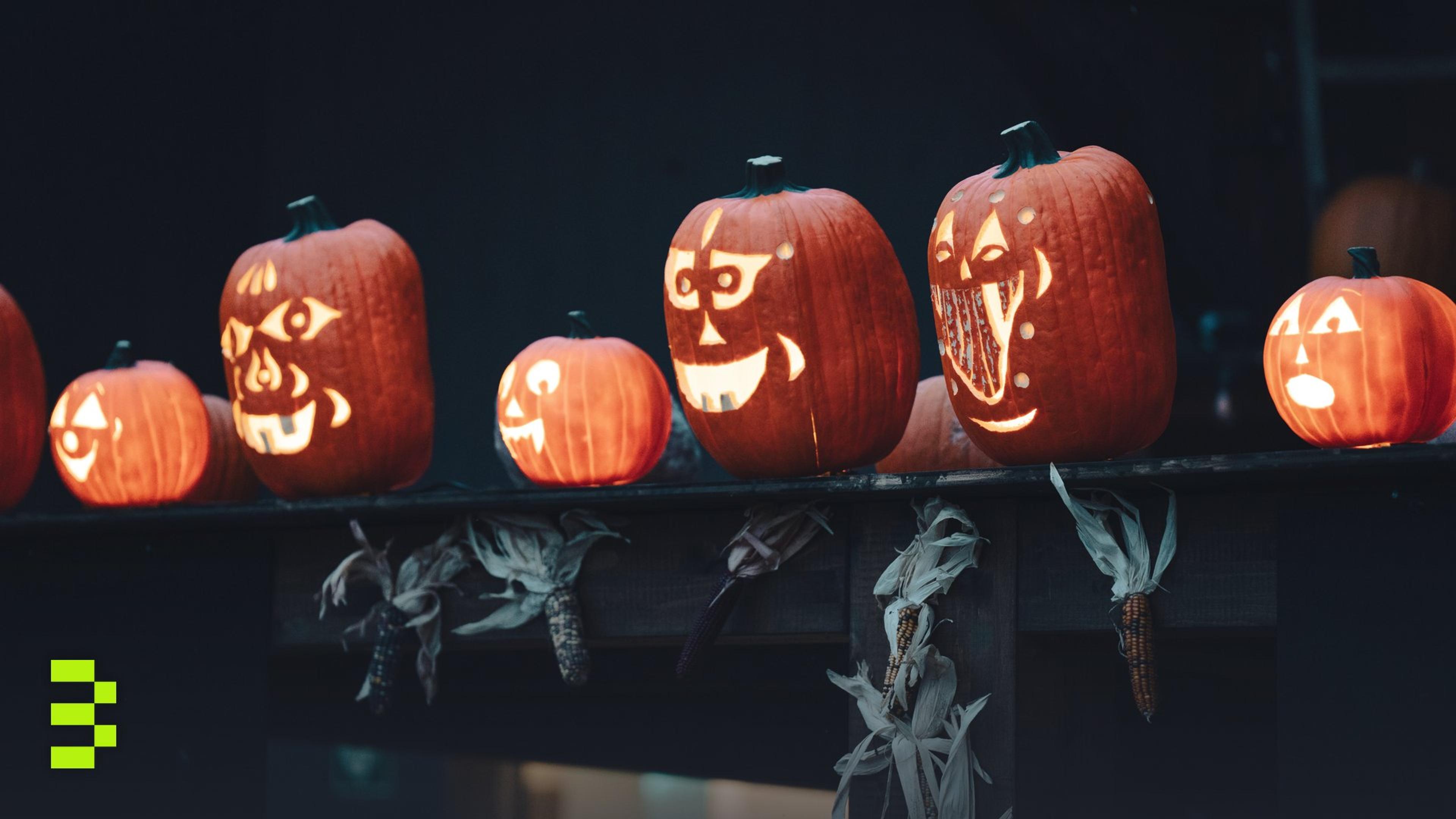 Row of creatively carved jack-o'-lantern pumpkins.
