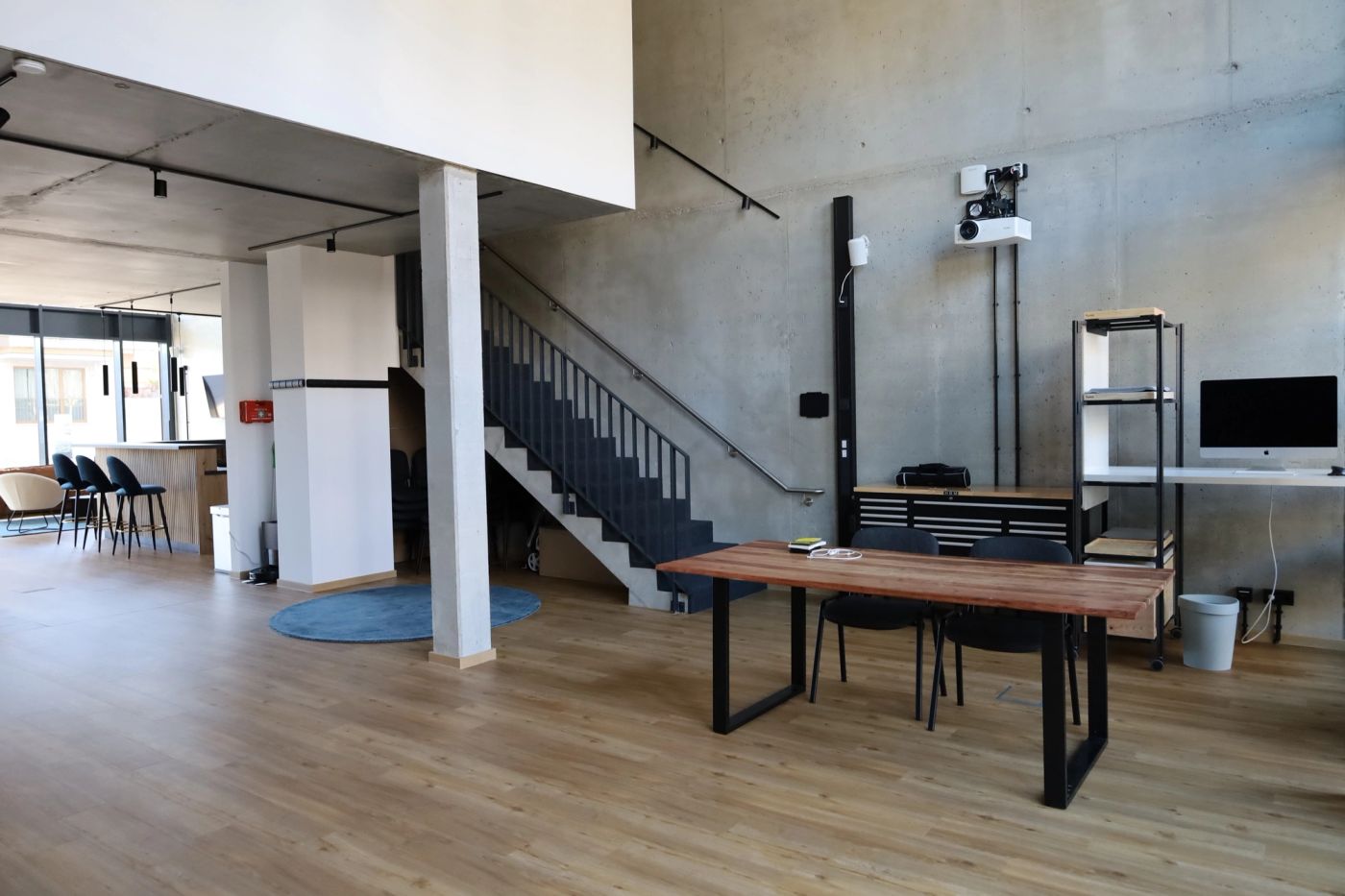 Die Workshop-Fläche im LechLoft: Sichtbeton, Eichenboden, offene schwarze Stahltreppe zur Galerie