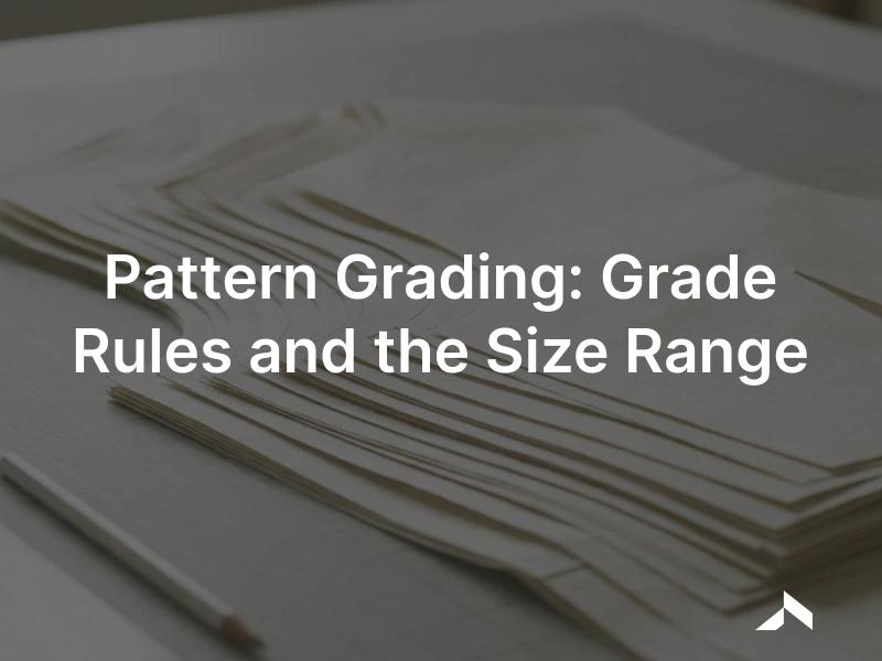 Pattern grading: a nest of graded garment pattern pieces overlaid in multiple sizes on a cutting table