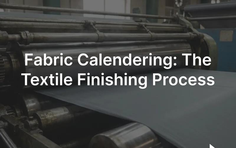 Rollers of an industrial textile calendering machine pressing a smooth length of fabric under bright light