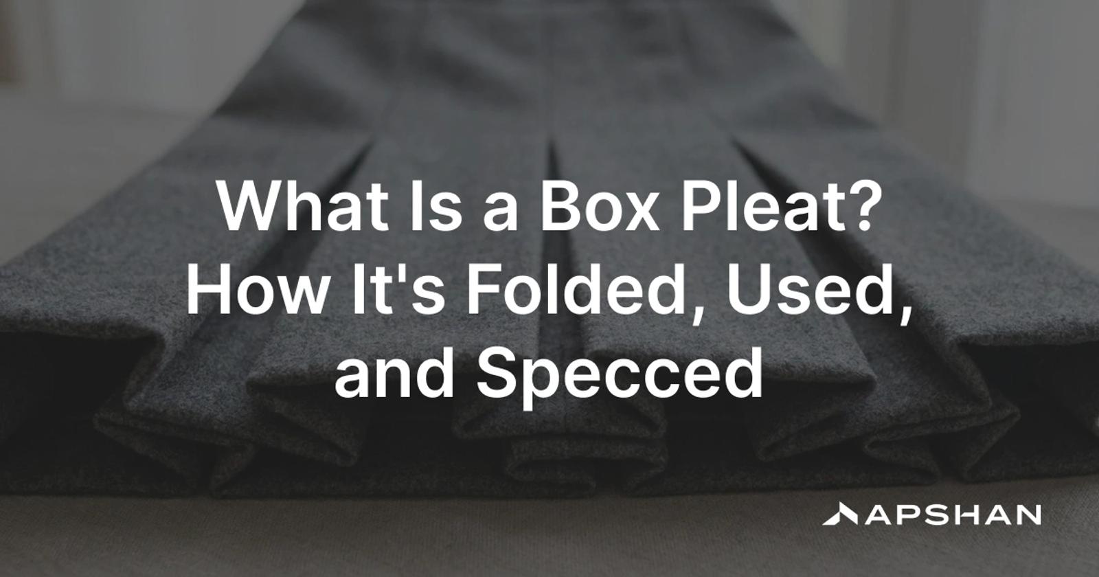 Close-up of crisp pressed box pleats on a grey wool skirt, the outer folds facing away from each other in an even row