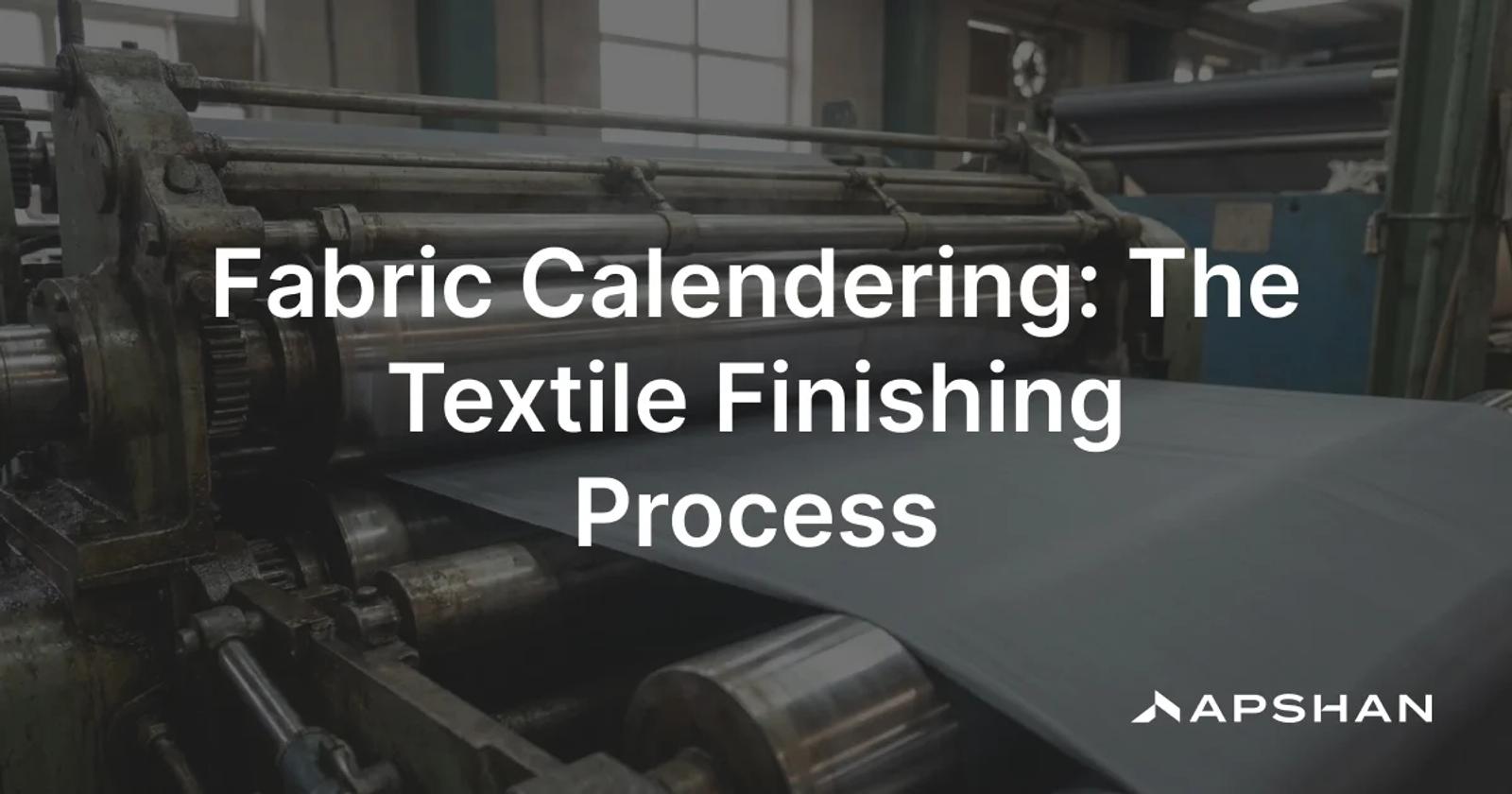 Rollers of an industrial textile calendering machine pressing a smooth length of fabric under bright light