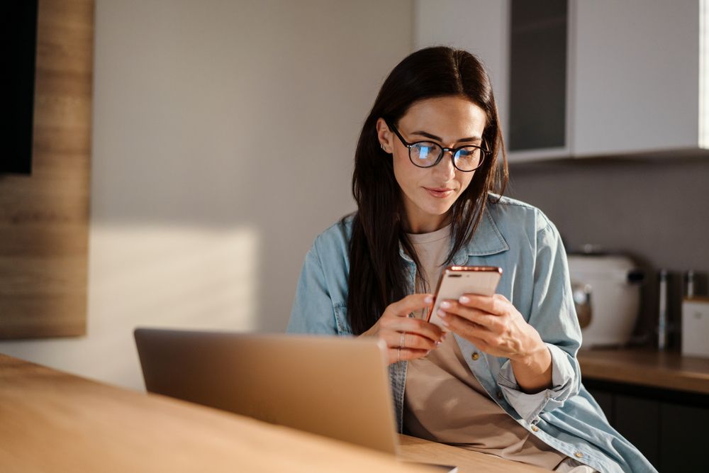 Young woman at home, looking at her phone