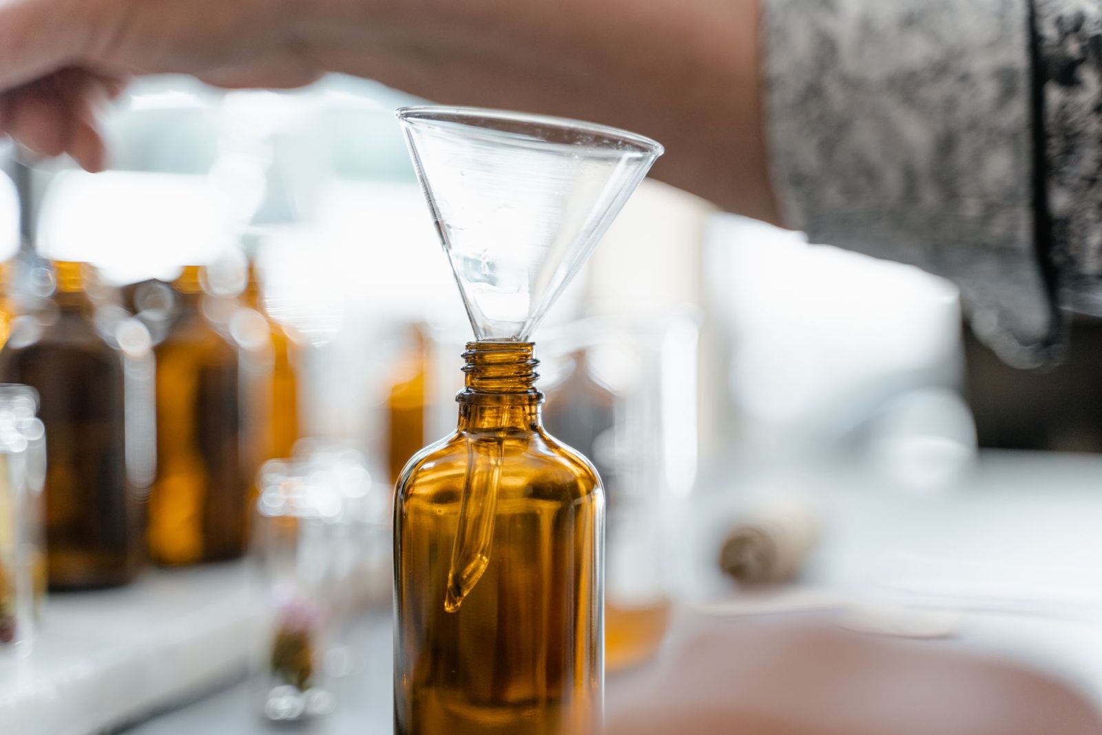A glass funnel resting in an amber bottle