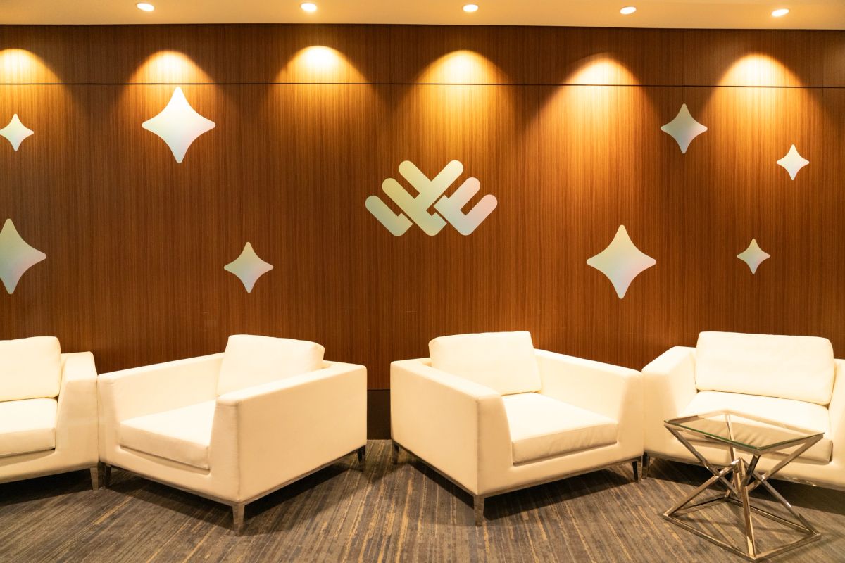 Hyatt Regency lobby seating area with white leather chairs, wood paneled wall, and decorative star accents.