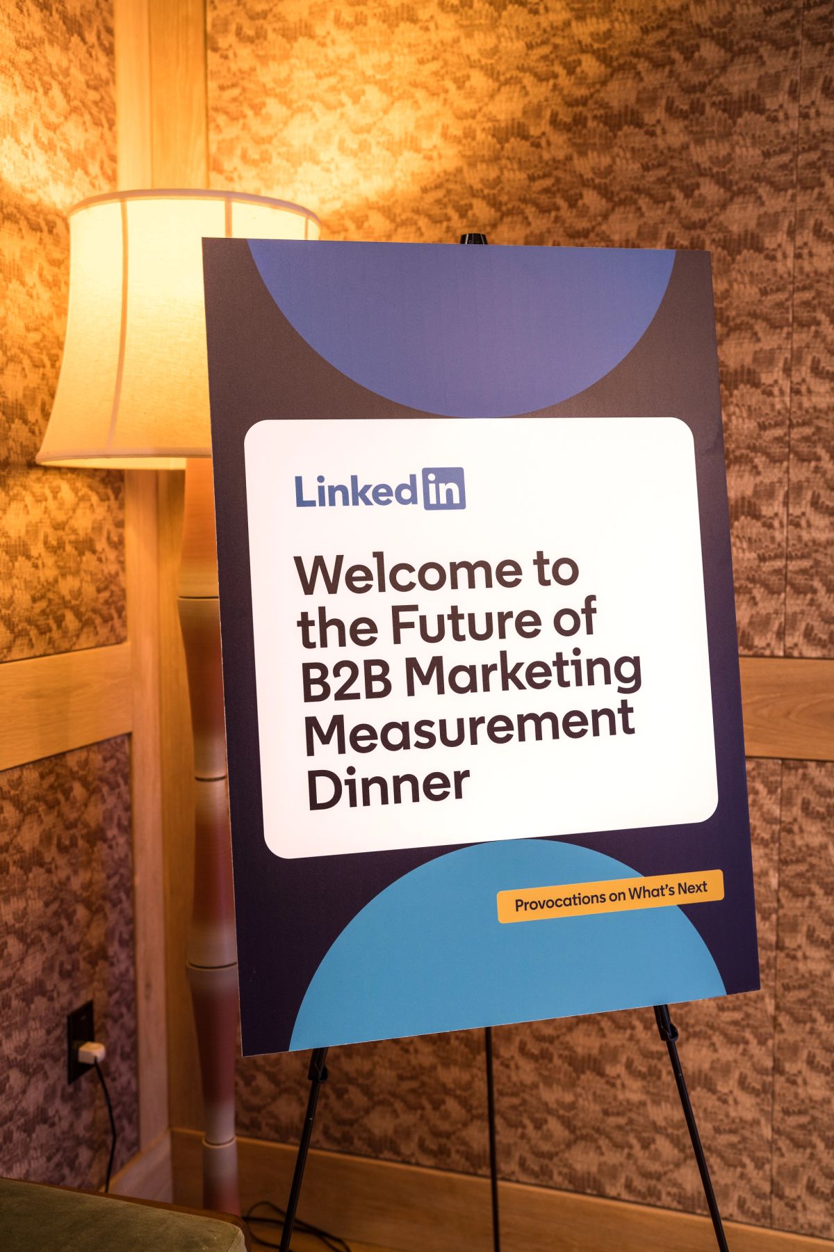 LinkedIn welcome sign on easel for B2B Marketing Measurement Dinner event in warm-lit venue interior