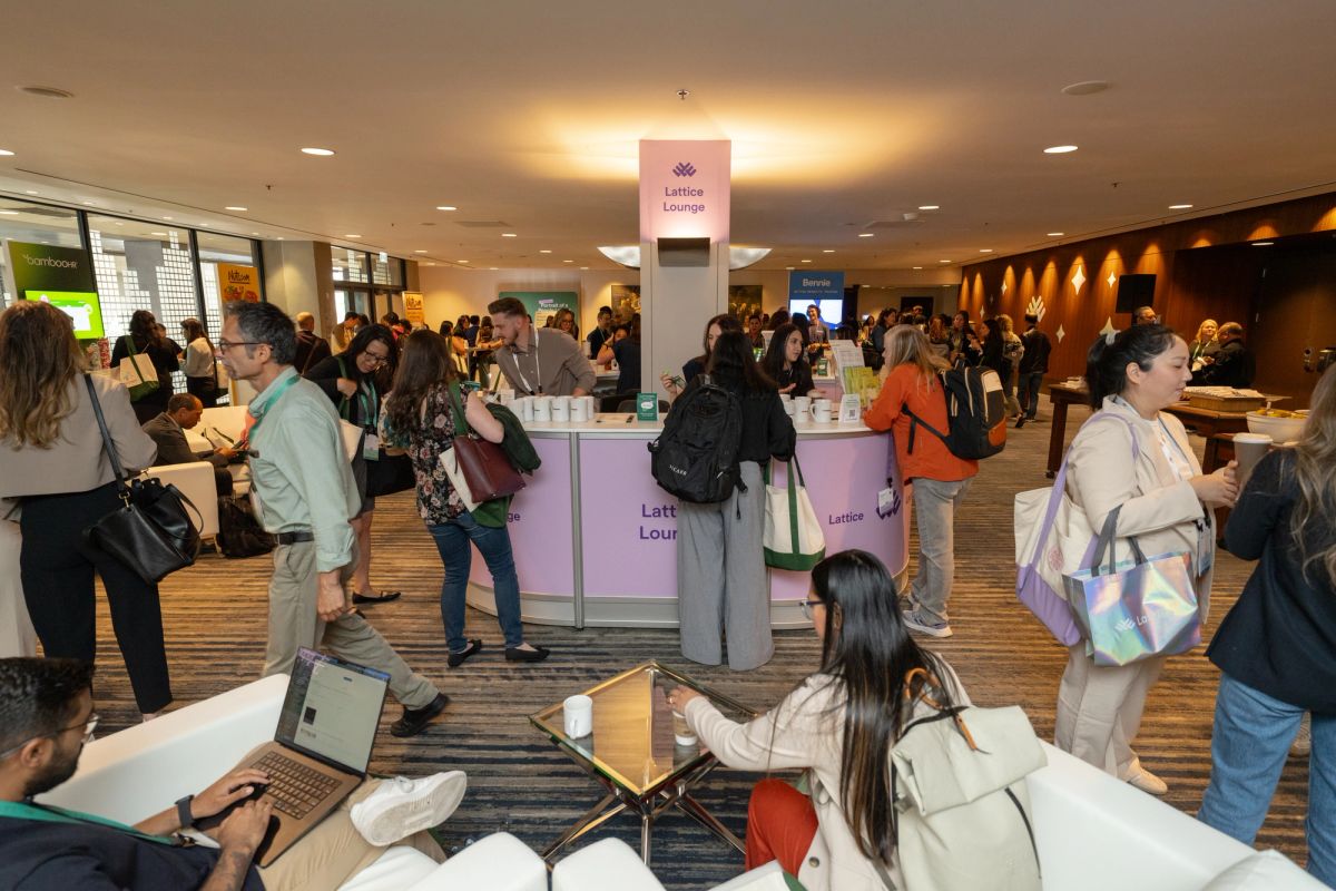 Attendees networking at the Lattice Lounge during a busy conference expo floor.