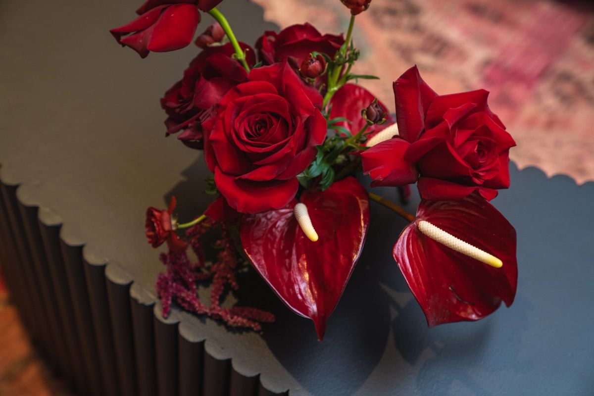 Red roses and anthurium flowers in an elegant floral arrangement at an upscale event venue