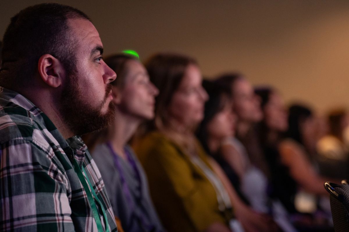 Attendees seated in rows watching a presentation at a conference session.