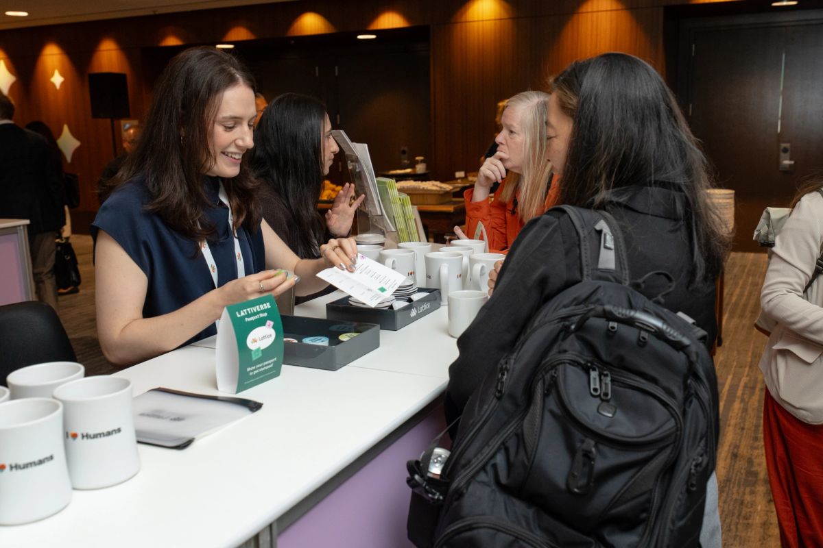 Attendees networking at a Lattice registration table during a conference.