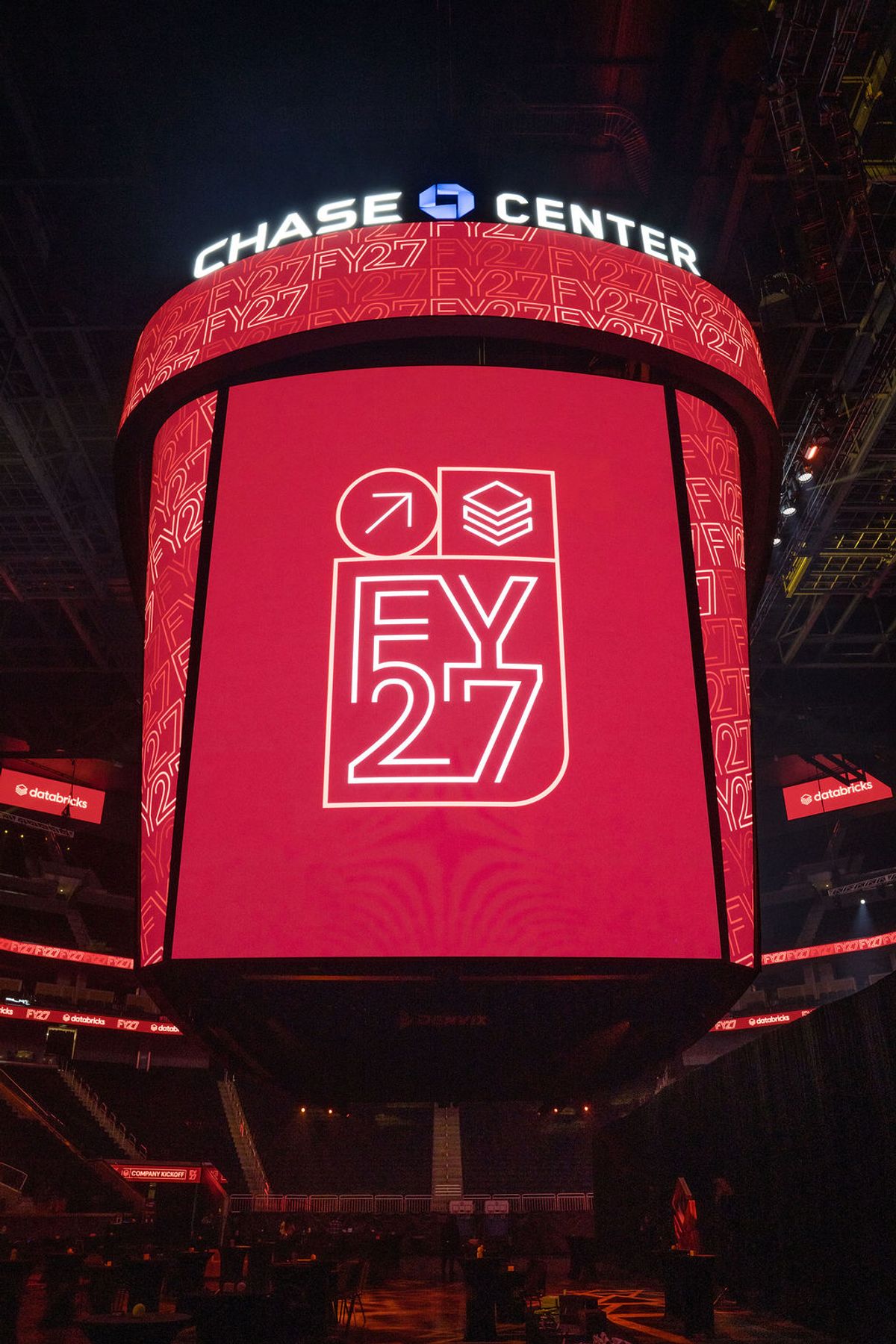 Speaker presenting on stage at Chase Center with large screen display and audience seating below
