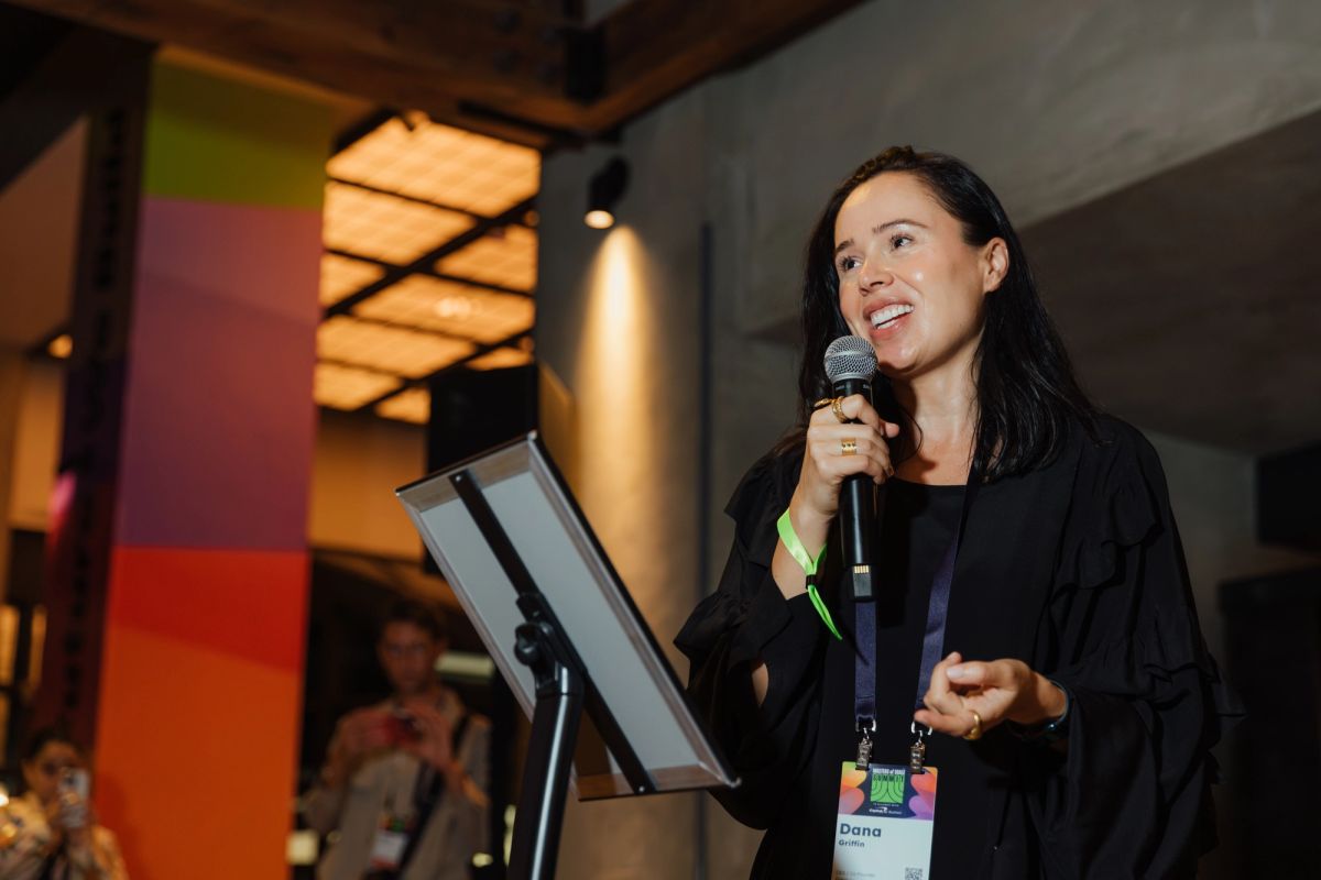 Female speaker presenting at conference with microphone and podium in modern venue