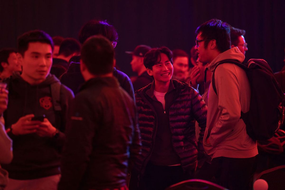 Attendees networking and socializing in purple-tinted lighting at a conference event