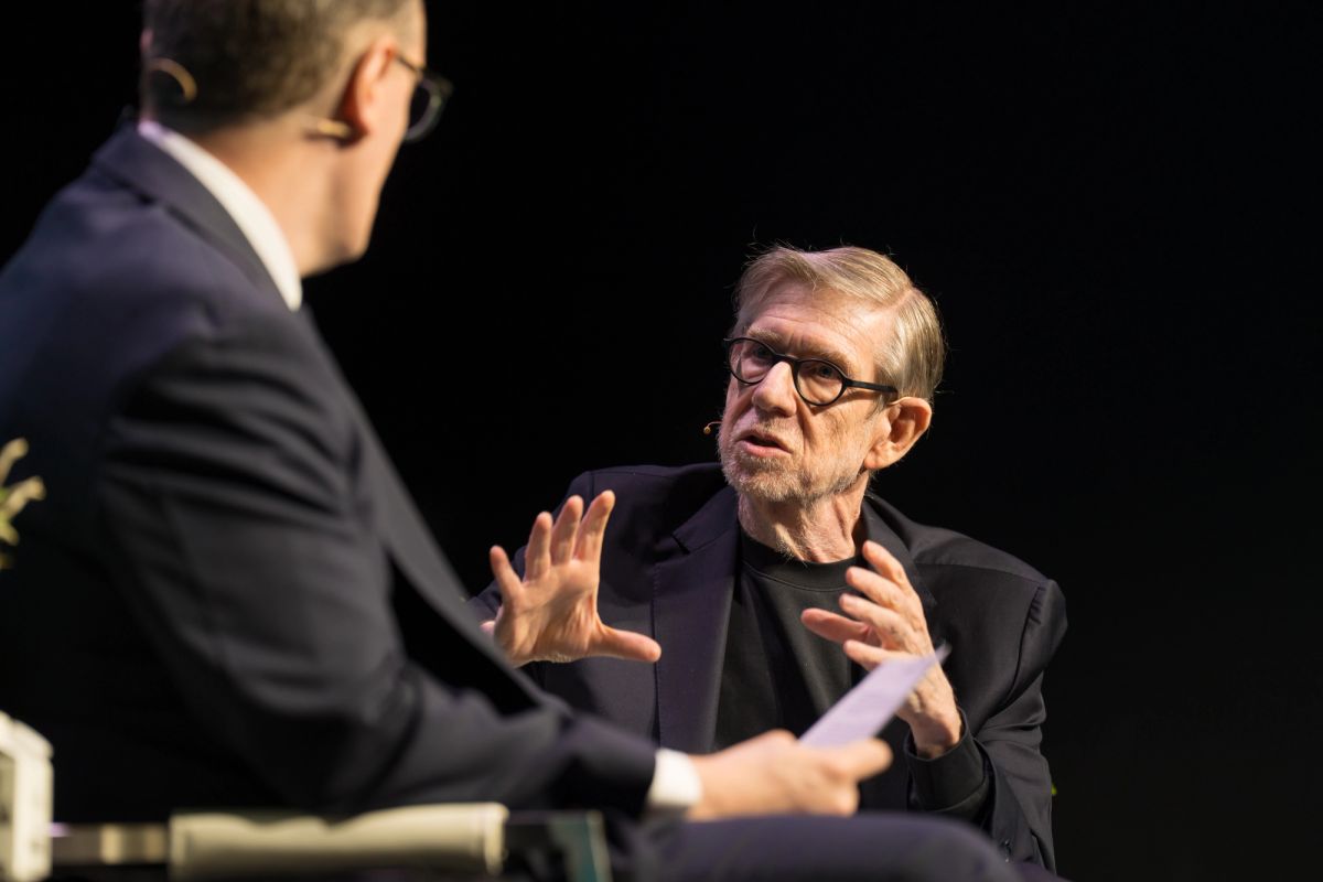 Two men in suits in a fireside chat discussion on stage at the STAT Breakthrough Summit