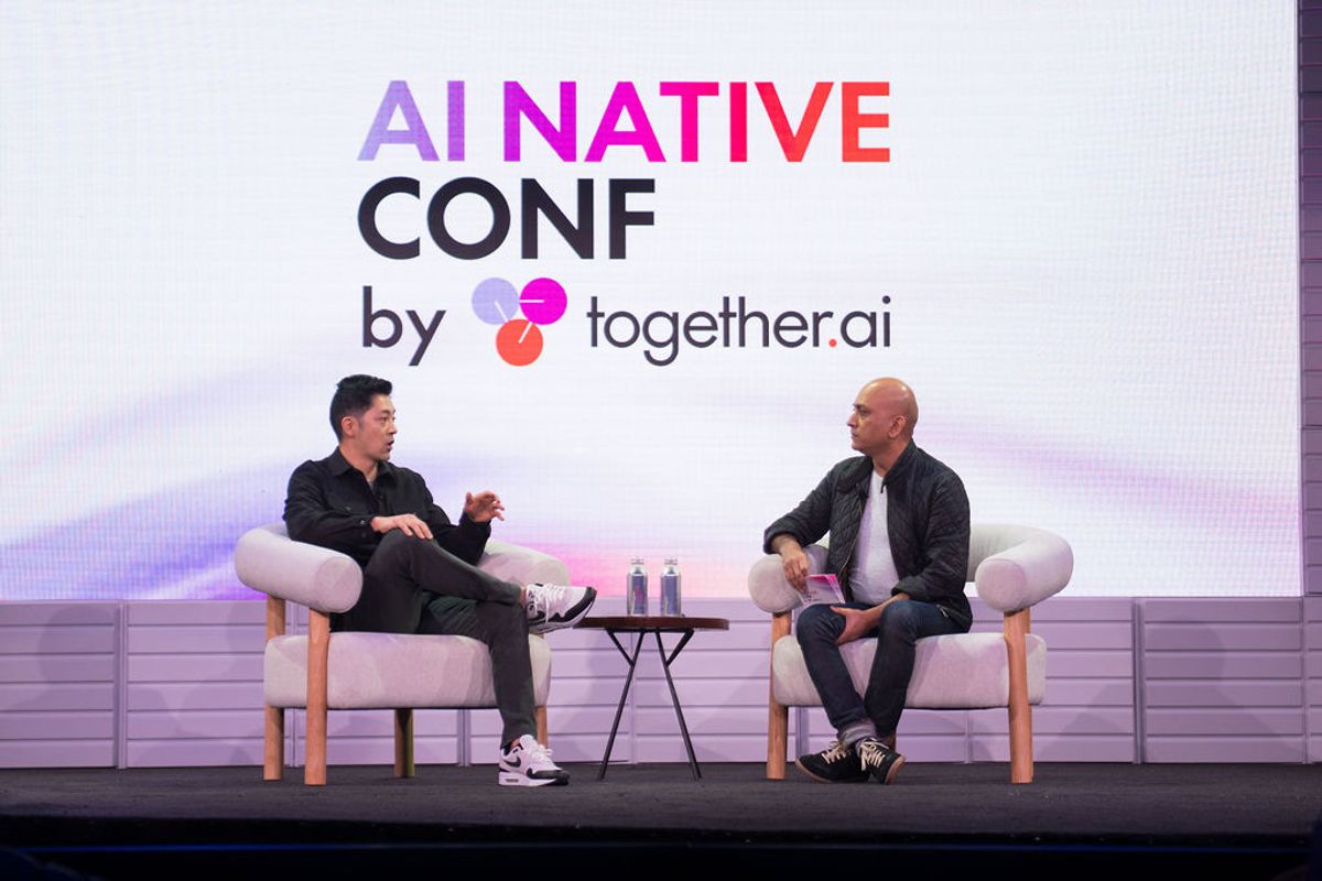 Two speakers in conversation on white chairs at AI Native Conf by together.ai event stage