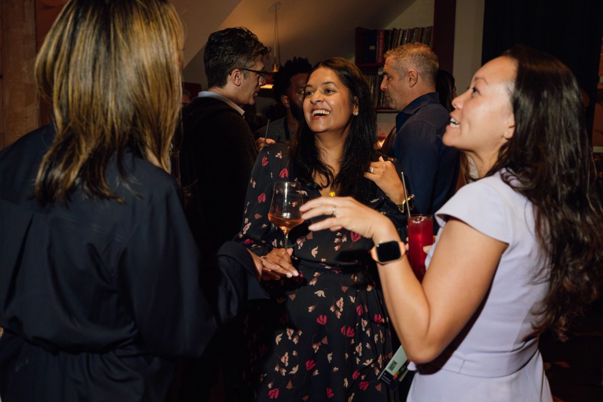 Conference attendees networking and socializing with drinks in an indoor venue