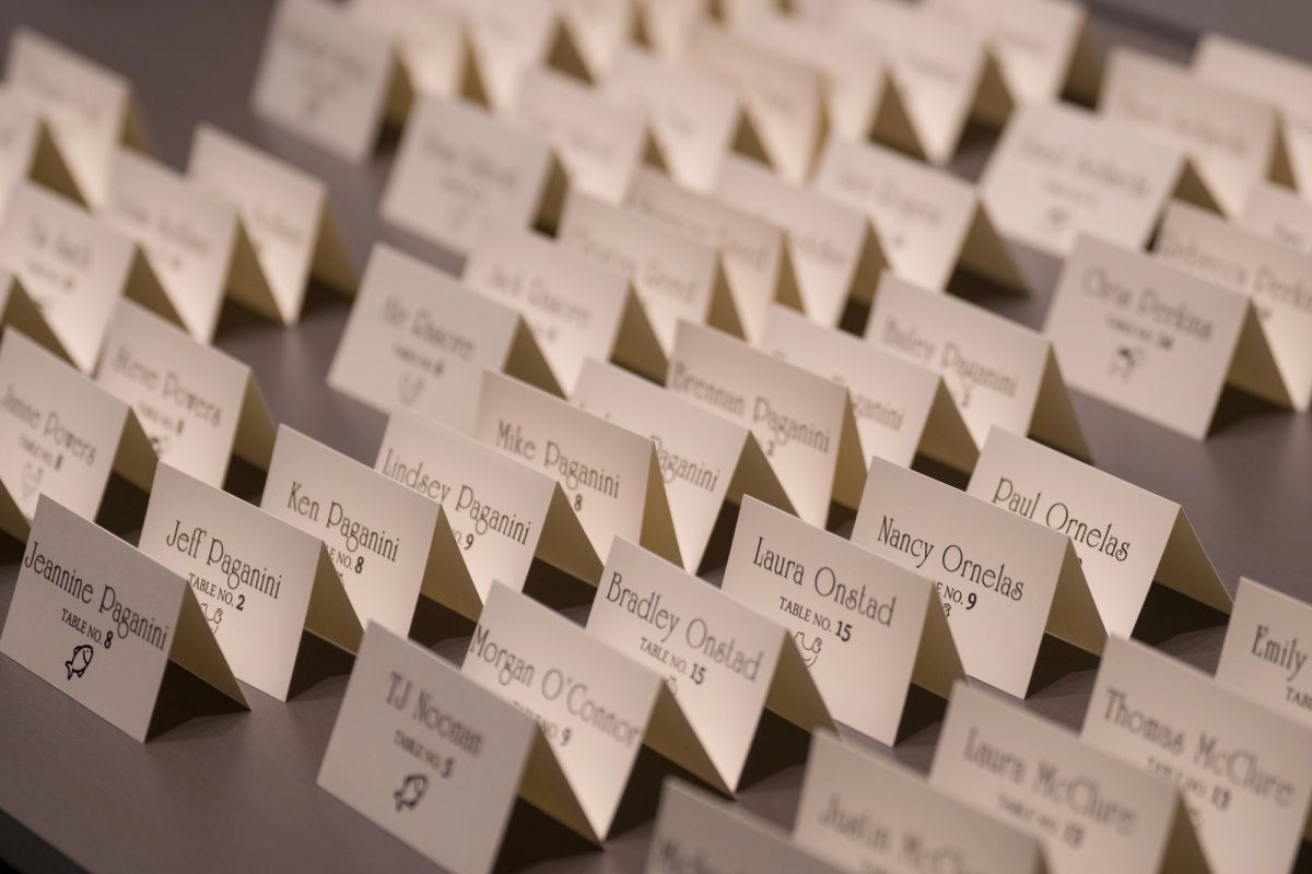 Place cards with guest names and table numbers arranged on a table at a formal event