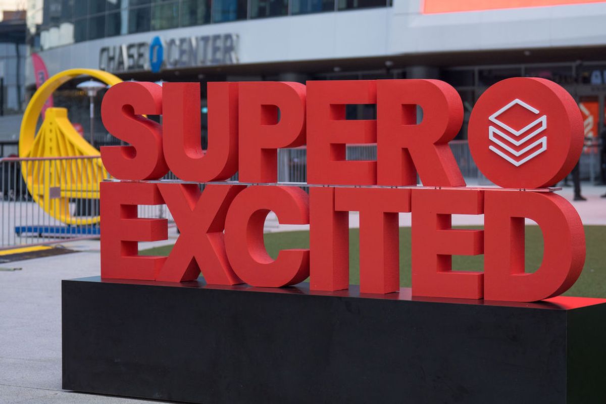 Large red "SUPER EXCITED" sign display at Chase Center with yellow sculptural elements in background