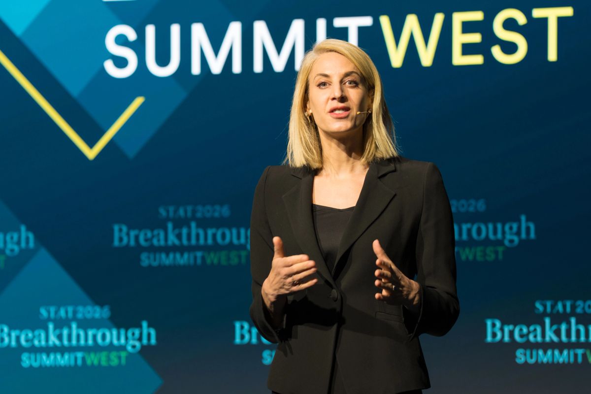 Blonde woman in black blazer speaking with hand gestures at Summit West Breakthrough conference event