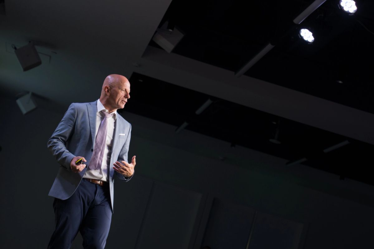 Keynote speaker under stage lights at a Corporate Conference at Convene SF