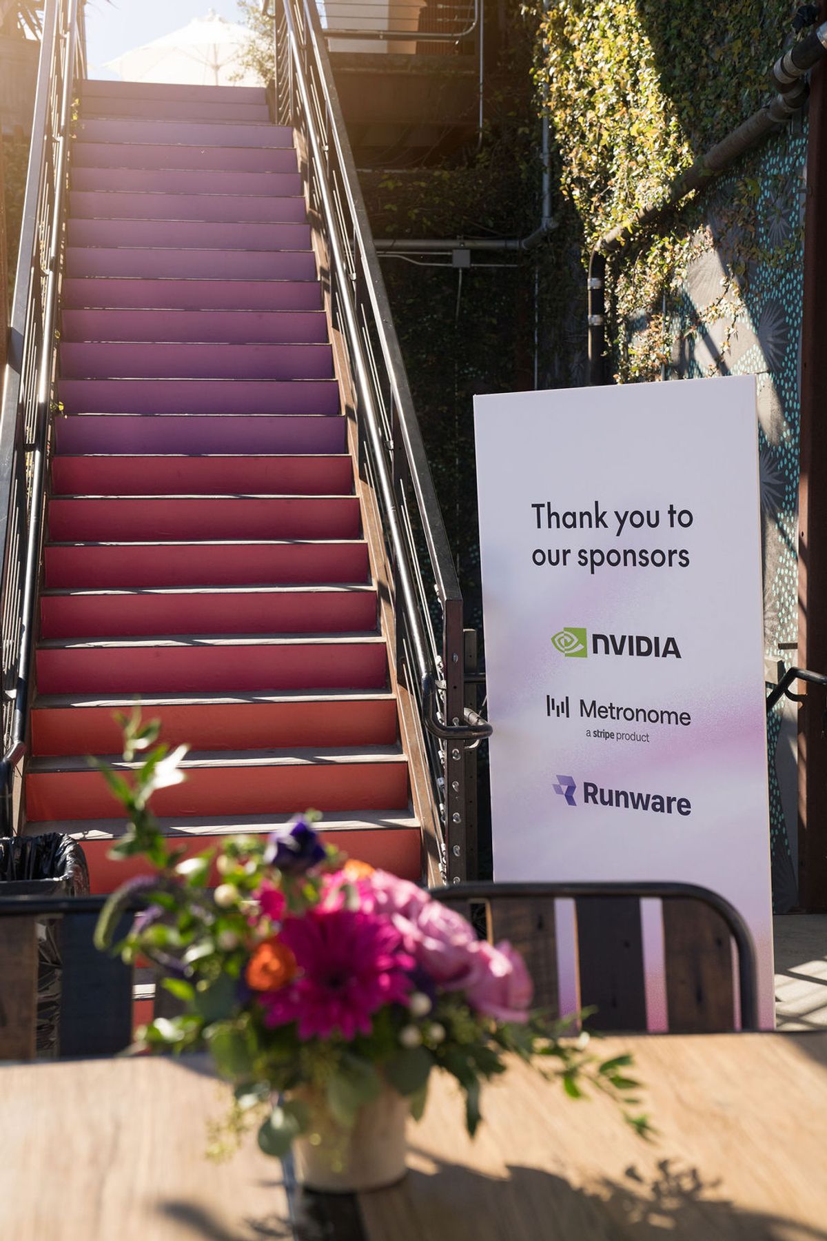 Sponsor thank you banner featuring NVIDIA, Metronome, and Runware logos next to red stairs and flowers