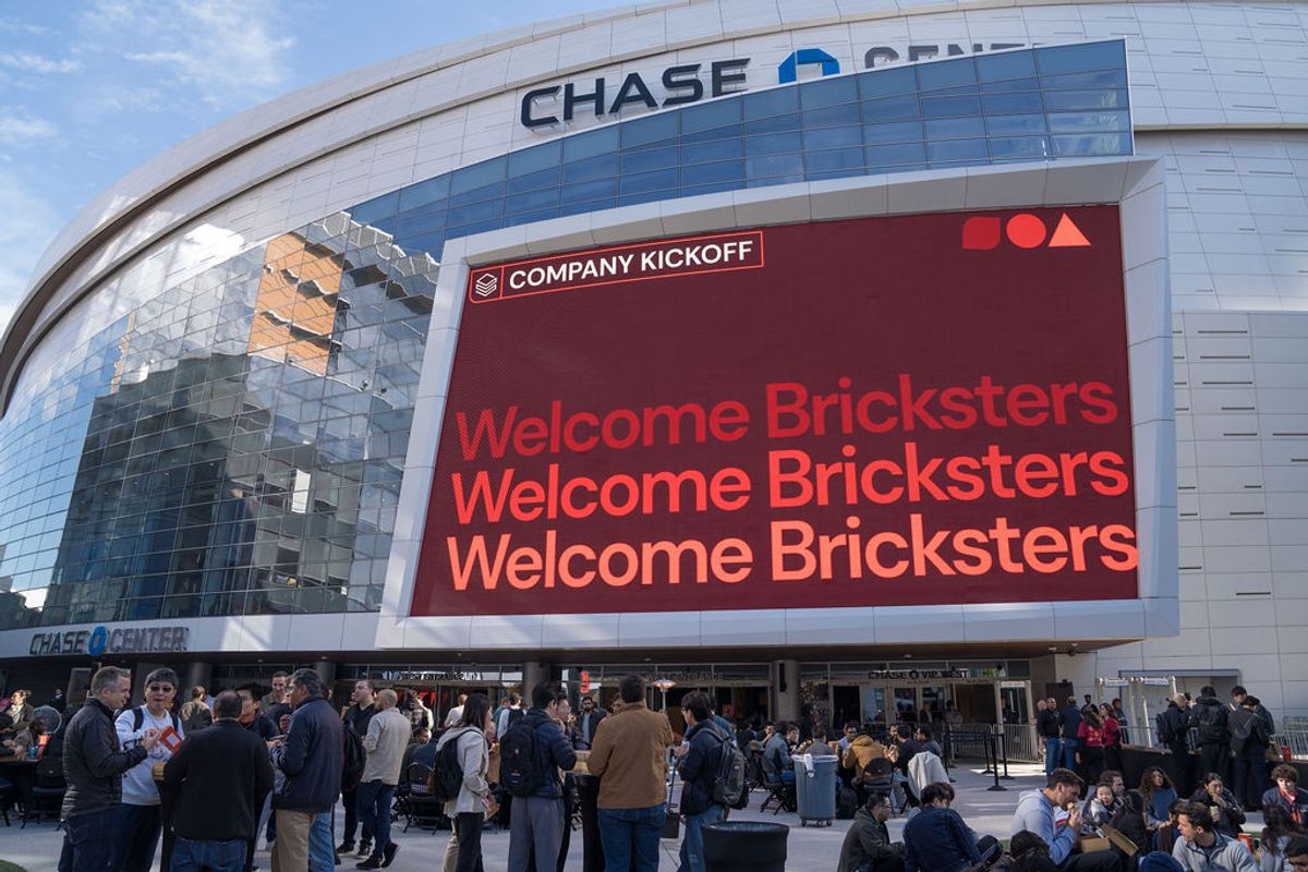 Large crowd of attendees gathered outside Chase Center with Databricks signage displayed on the building