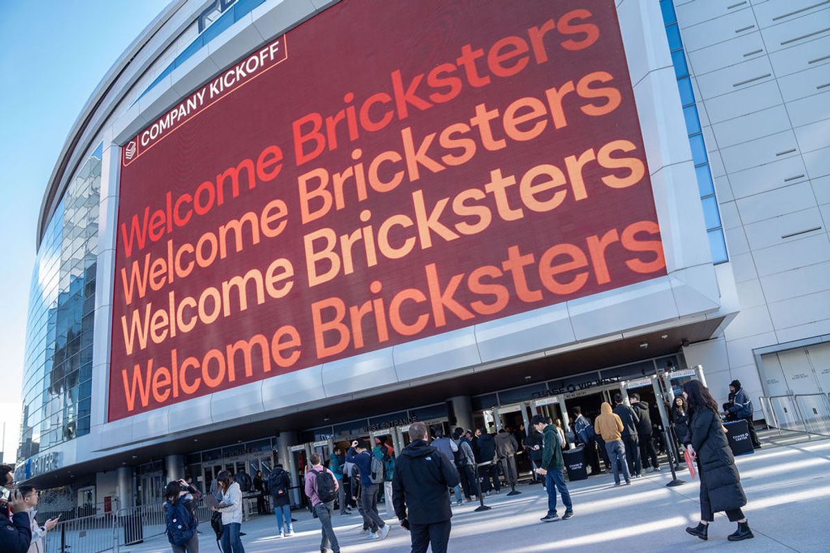 Attendees gather outside Chase Center with large red "Welcome Bricksters" sign displayed on building