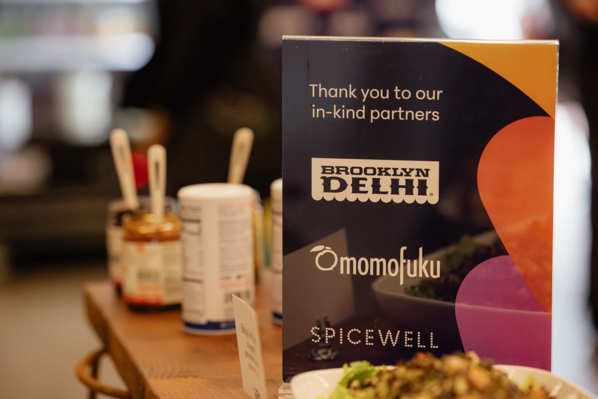 Thank you card for in-kind partners Brooklyn Delhi, Omomfuku, and Spicewell next to drinks and food