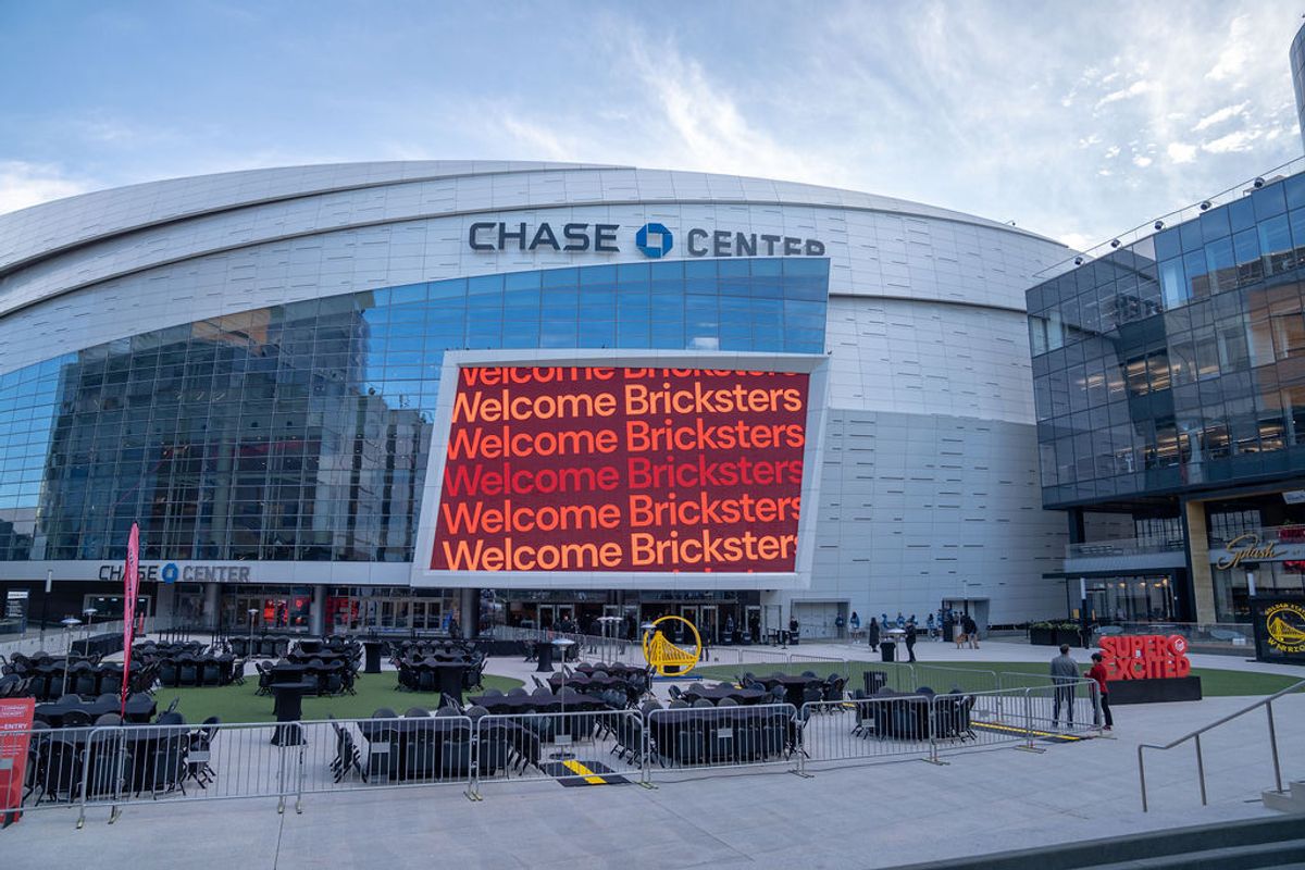 Chase Center exterior with large digital display showing "Welcome Bricksters" message and metal barriers