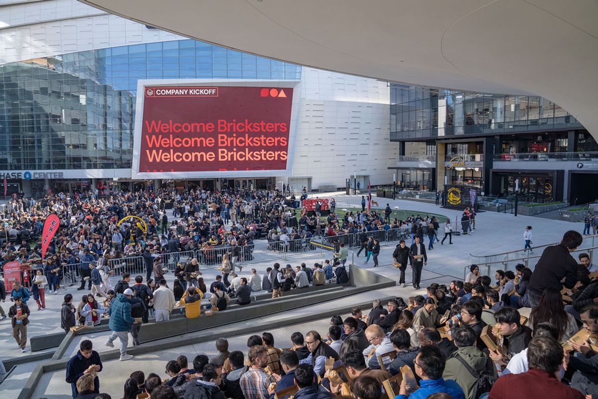 Large crowd of attendees gathered on steps and plaza area at Chase Center with "Welcome Bricksters" displayed.