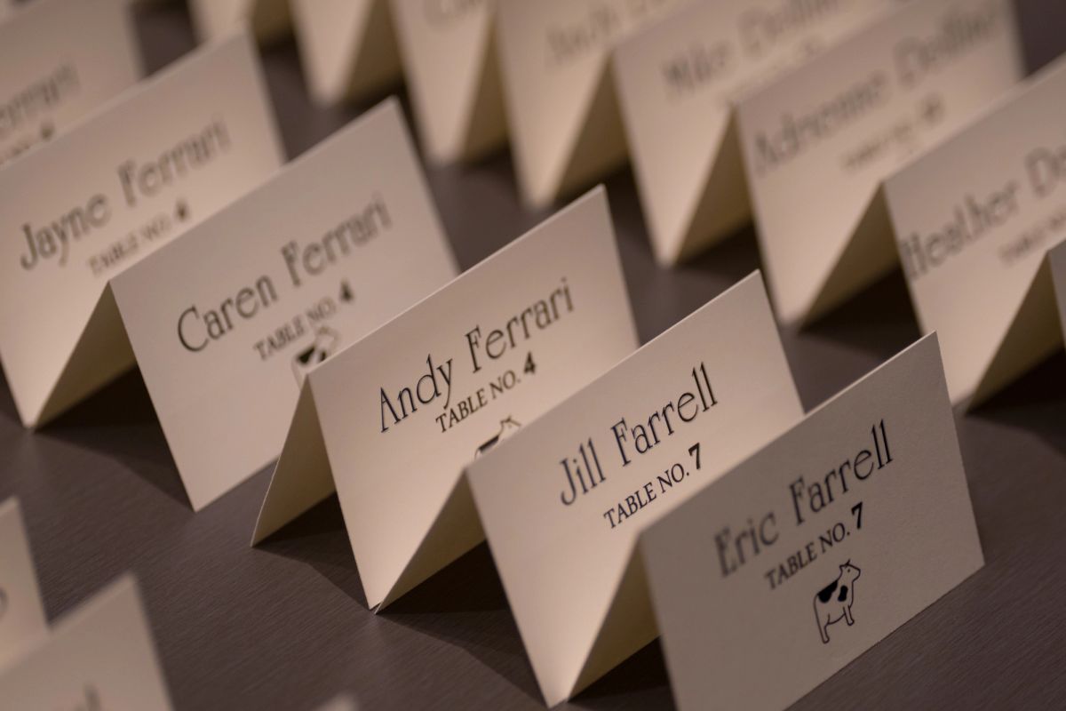 Place cards arranged in rows showing guest names and table assignments for a formal event