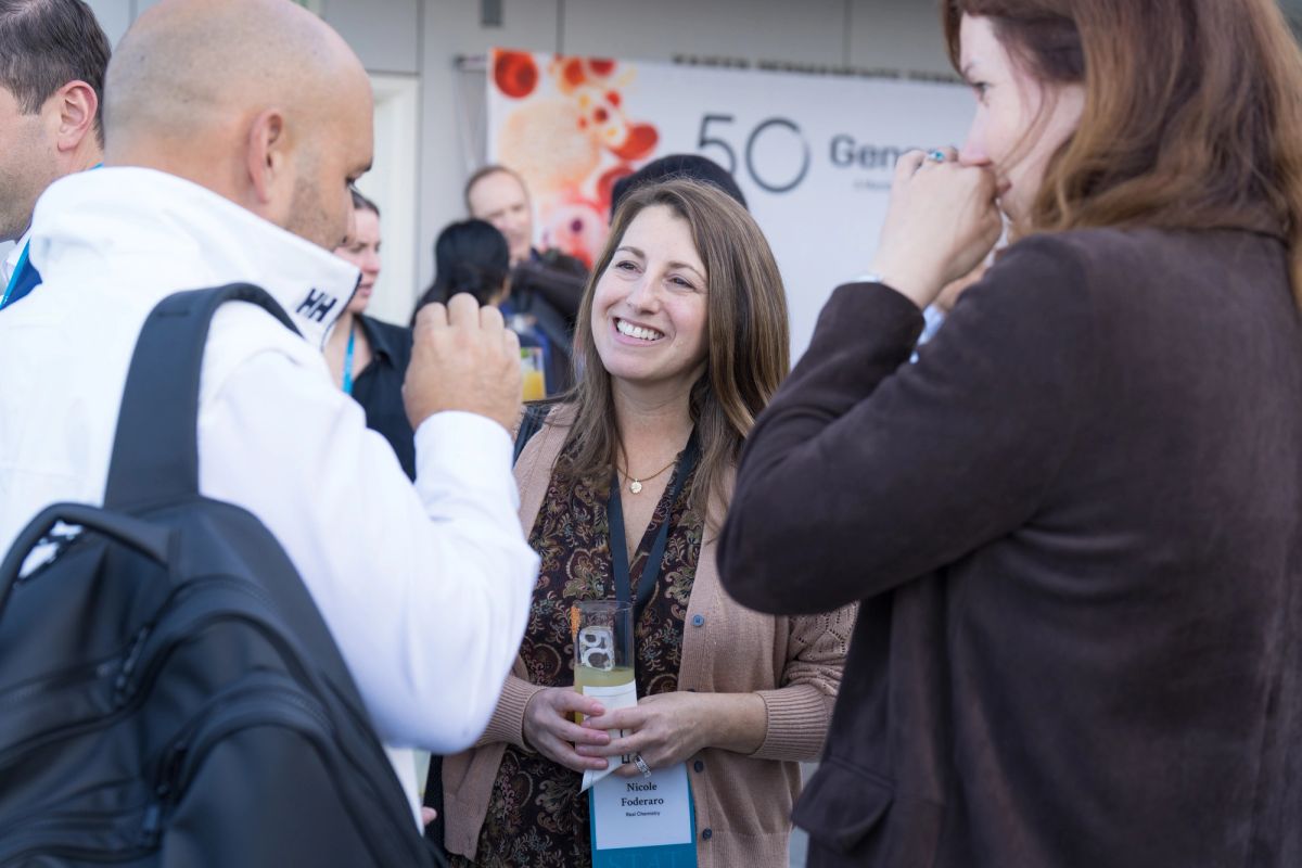 Attendees networking at a conference event, with people in business attire engaged in conversation