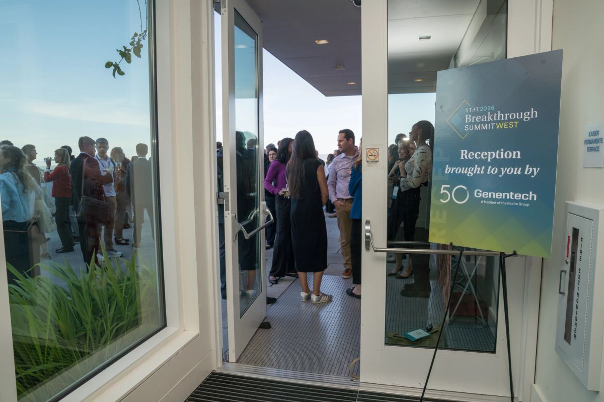 Attendees networking at a Breakthrough Summit West reception sponsored by Genentech in a modern venue