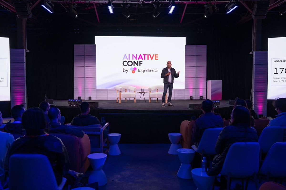 Speaker presenting to seated audience at AI Native Conf by together.ai conference with purple stage lighting