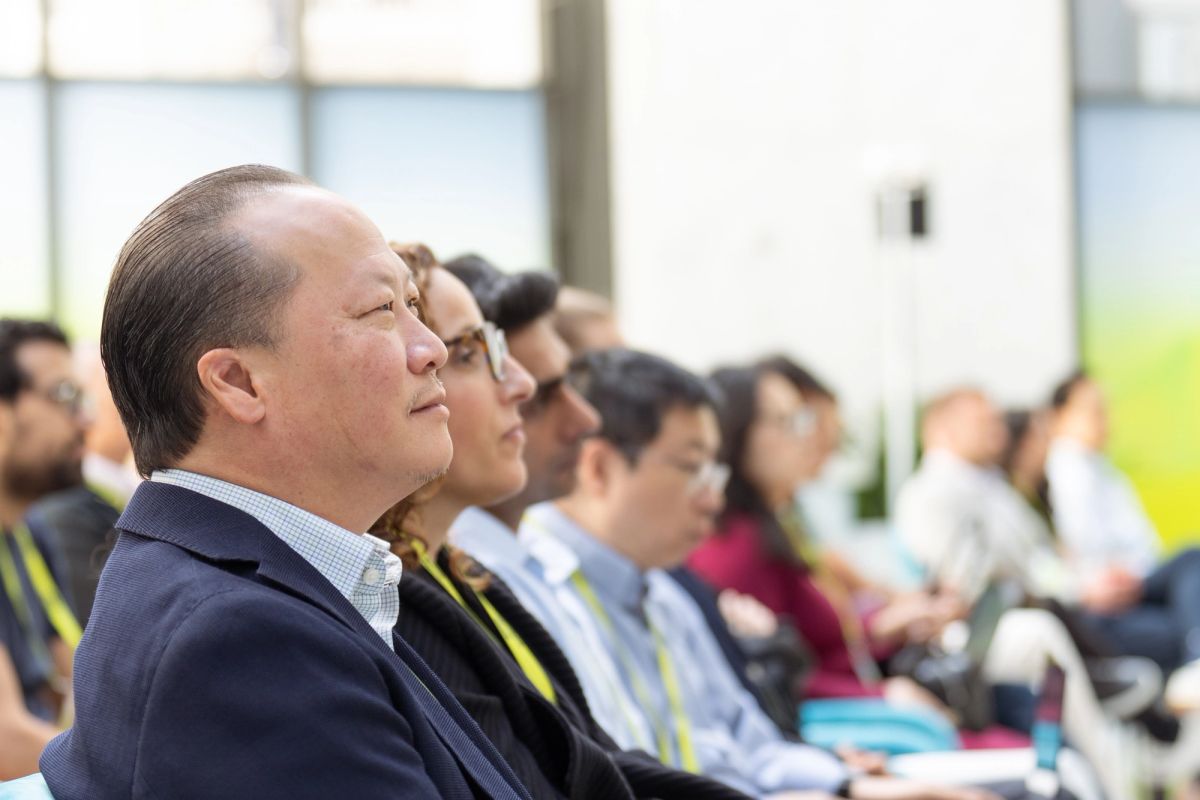 Attendees seated and listening attentively during a conference session indoors.