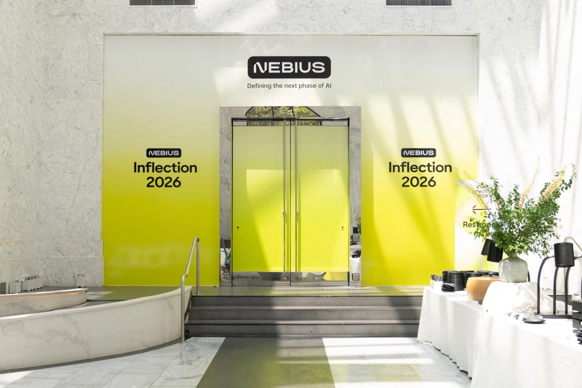 Nebius Inflection 2026 event entrance with bright yellow branded backdrop and glass doors.