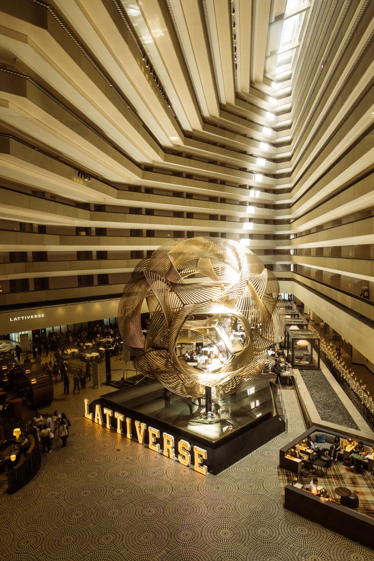 Lattiverse golden sphere sculpture in Hyatt Regency San Francisco's grand atrium lobby.
