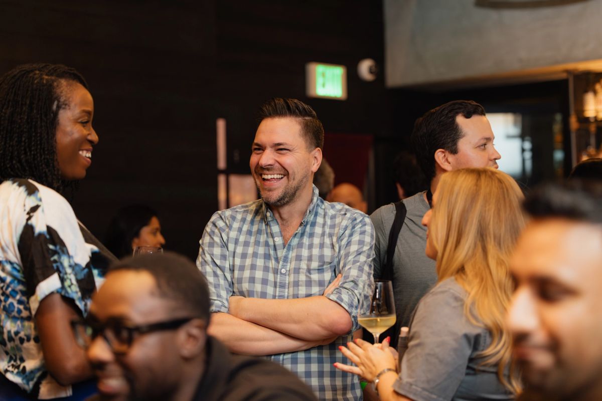 Attendees laughing and networking at conference event in theater venue