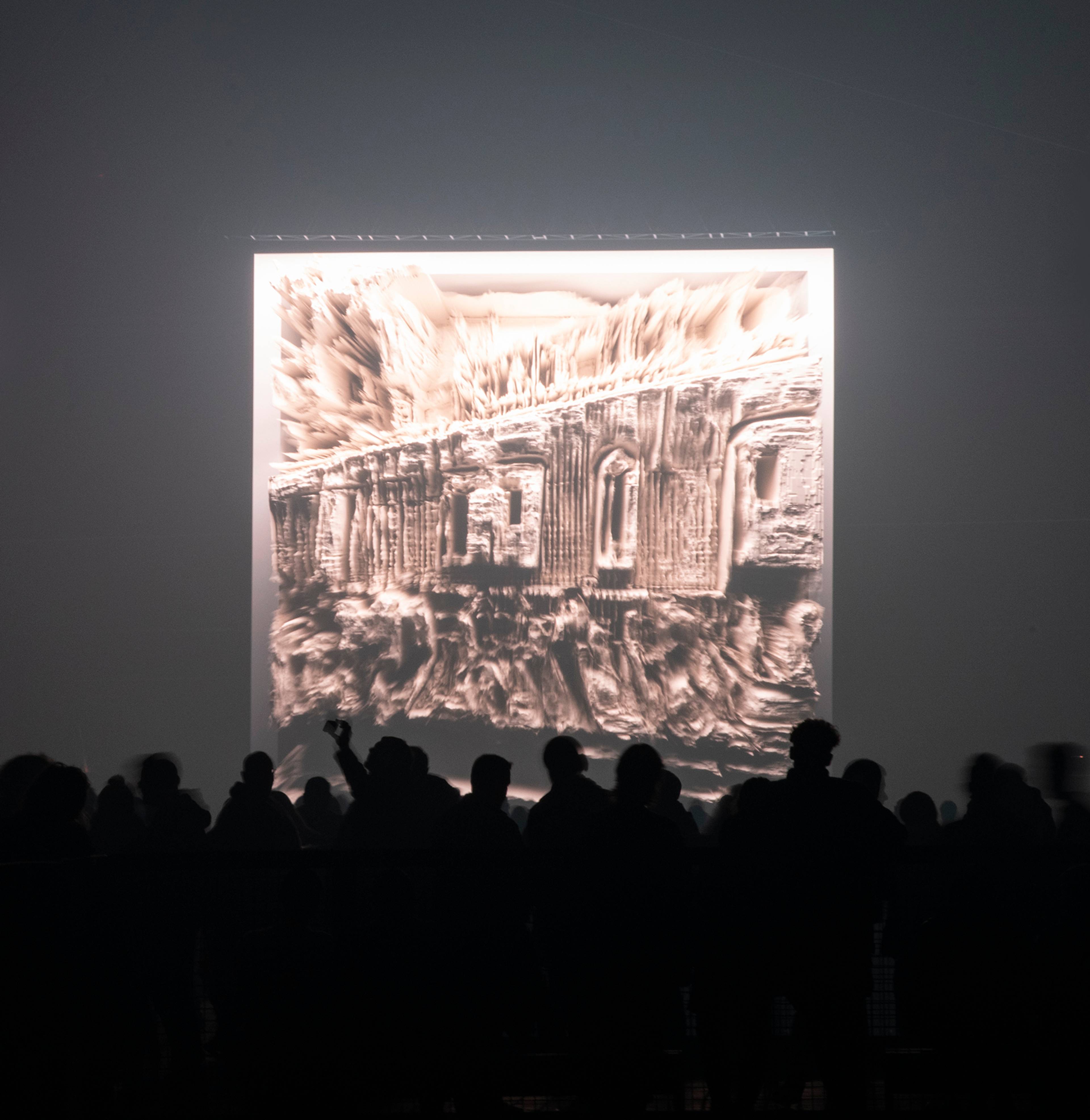 Large-scale AI data painting displayed on an LED wall in front of a large crowd.