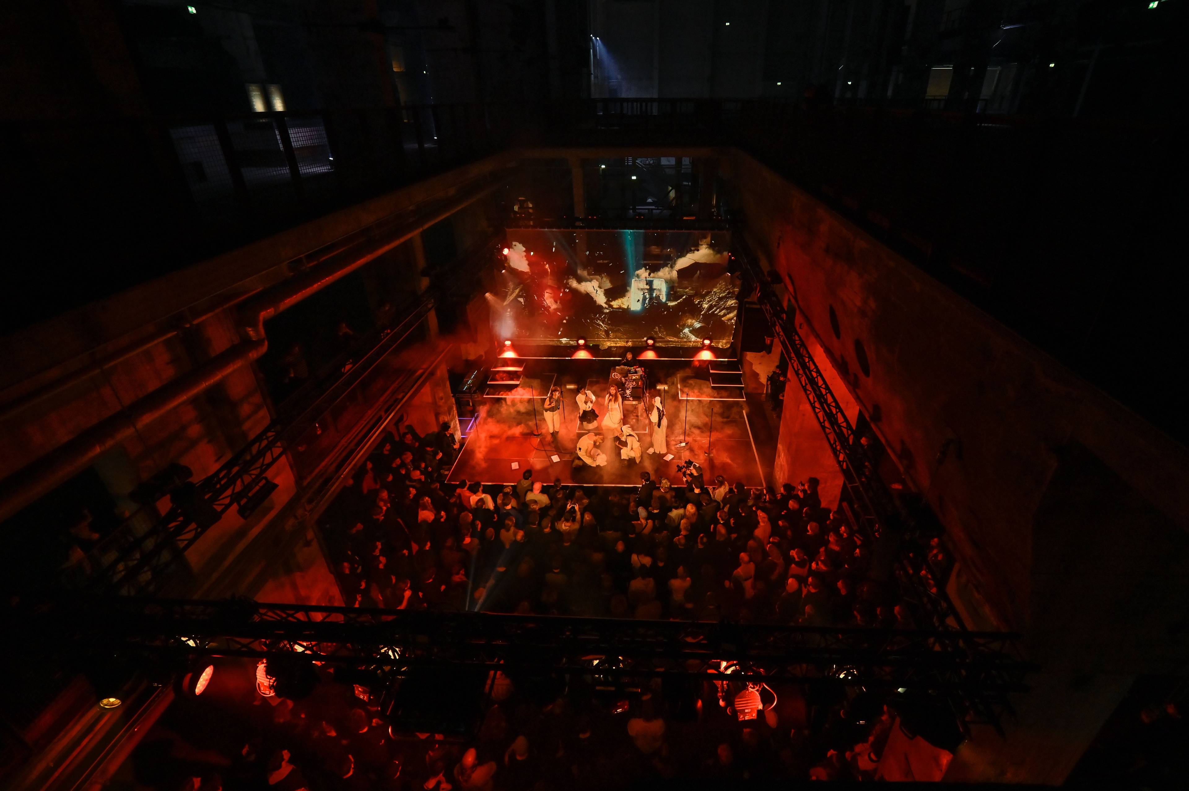 Wide-angle shot of the stage and audience at Holly Herndon's PROTO (Restaged) at Kraftwerk Berlin.