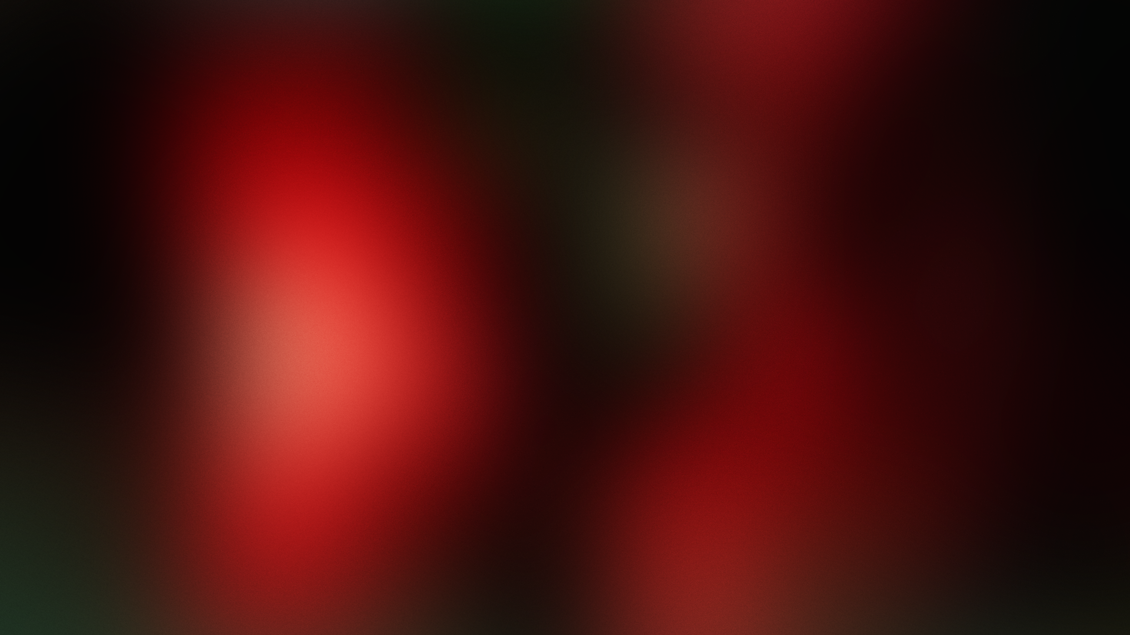 Abstract dark background with soft red and black gradients.