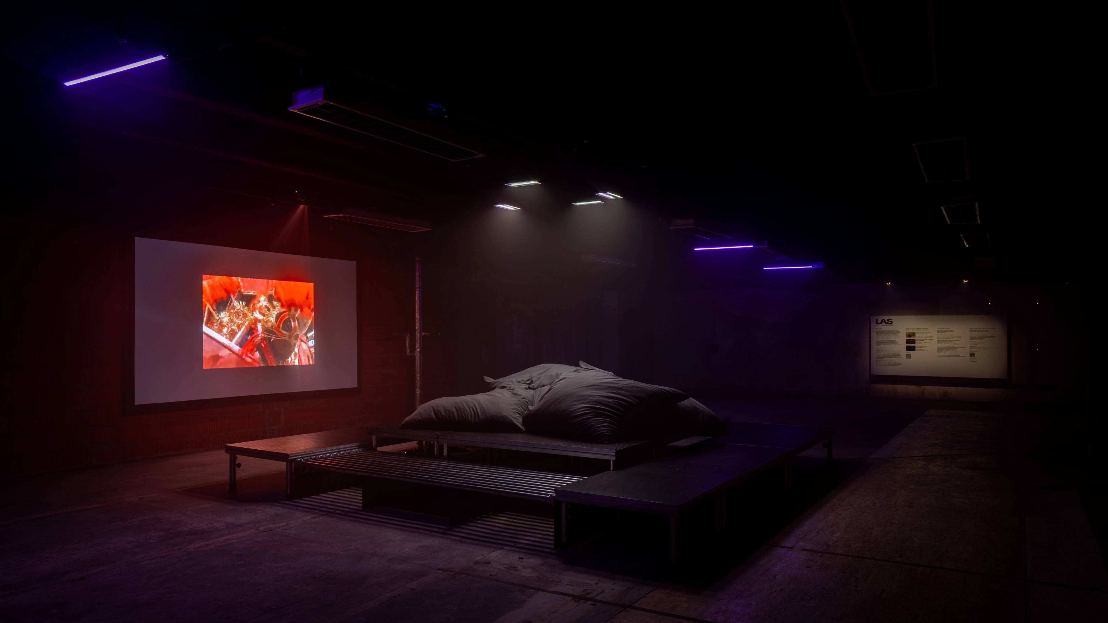 A DJ and rapper perform at a crowded indoor event, with the audience closely gathered around, enjoying the show.