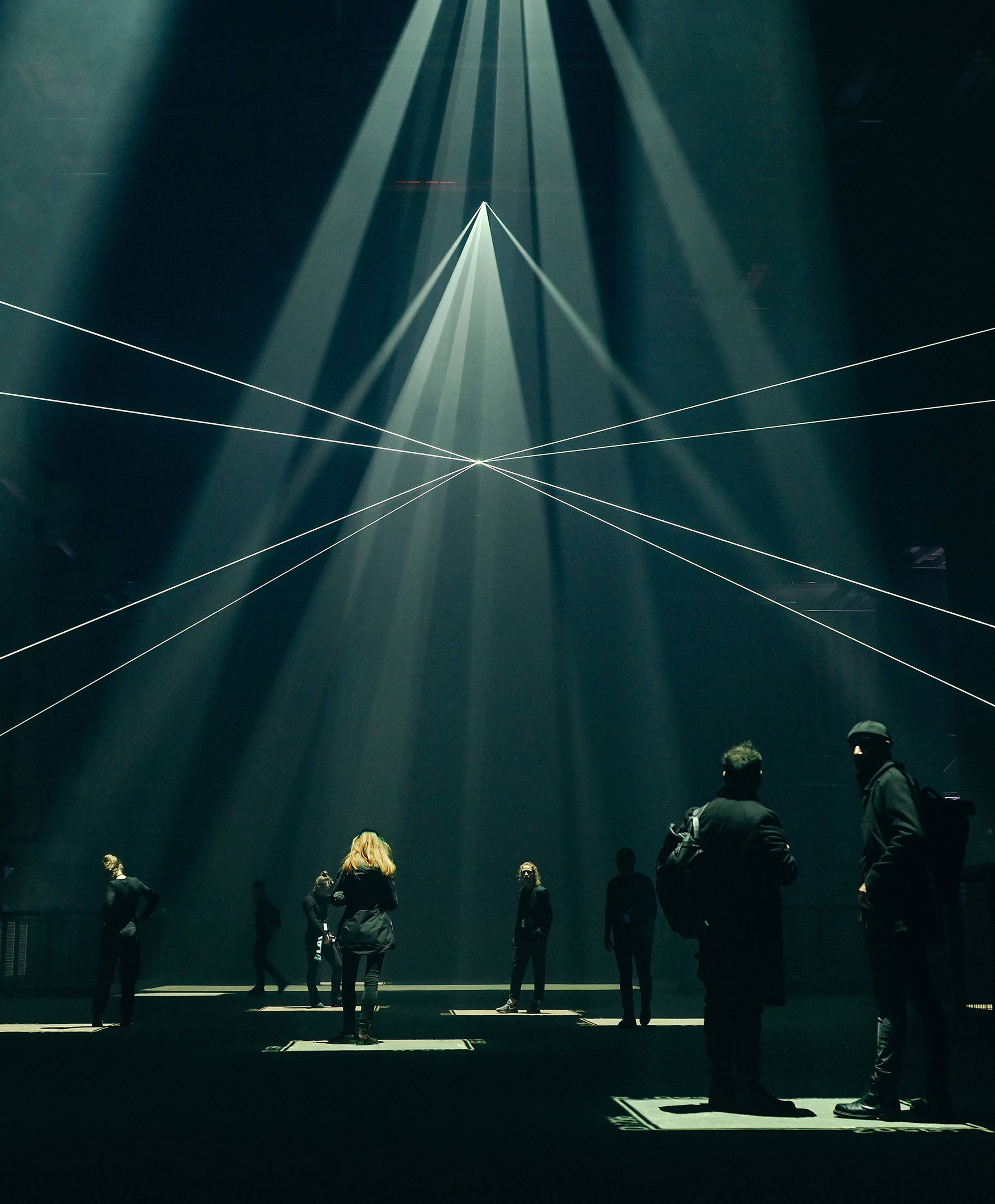 Triangular patterns of light criss-crossing above audience members in Kraftwerk Berlin's cavernous art space.