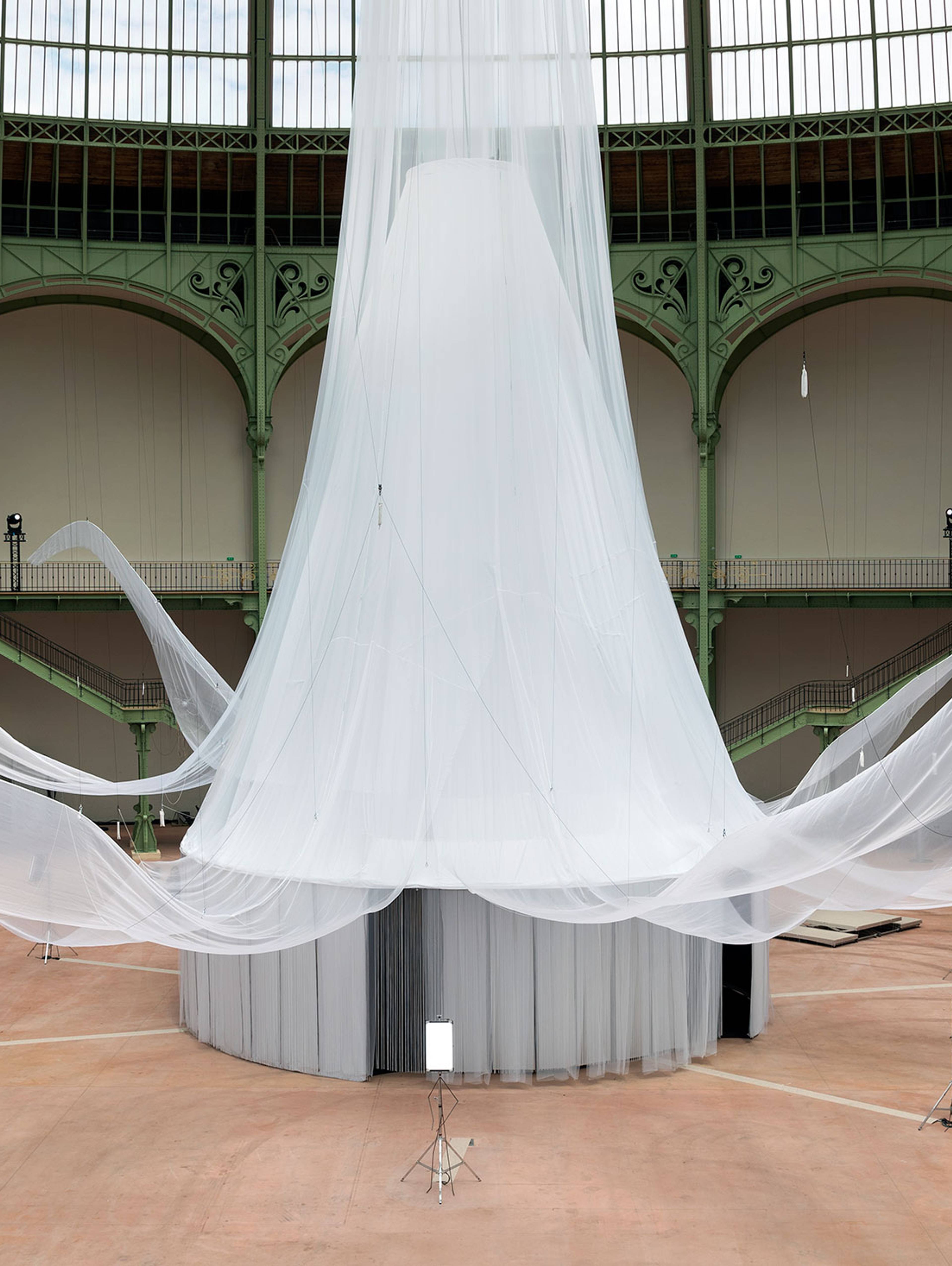 Laure Prouvost’s We Felt A Star Dying at the Grand Palais in Paris. A monumental, cloud-like installation made of delicate white mesh floats beneath the historic glass roof, unfolding in organic forms that evoke movement, cosmic matter and imagination.