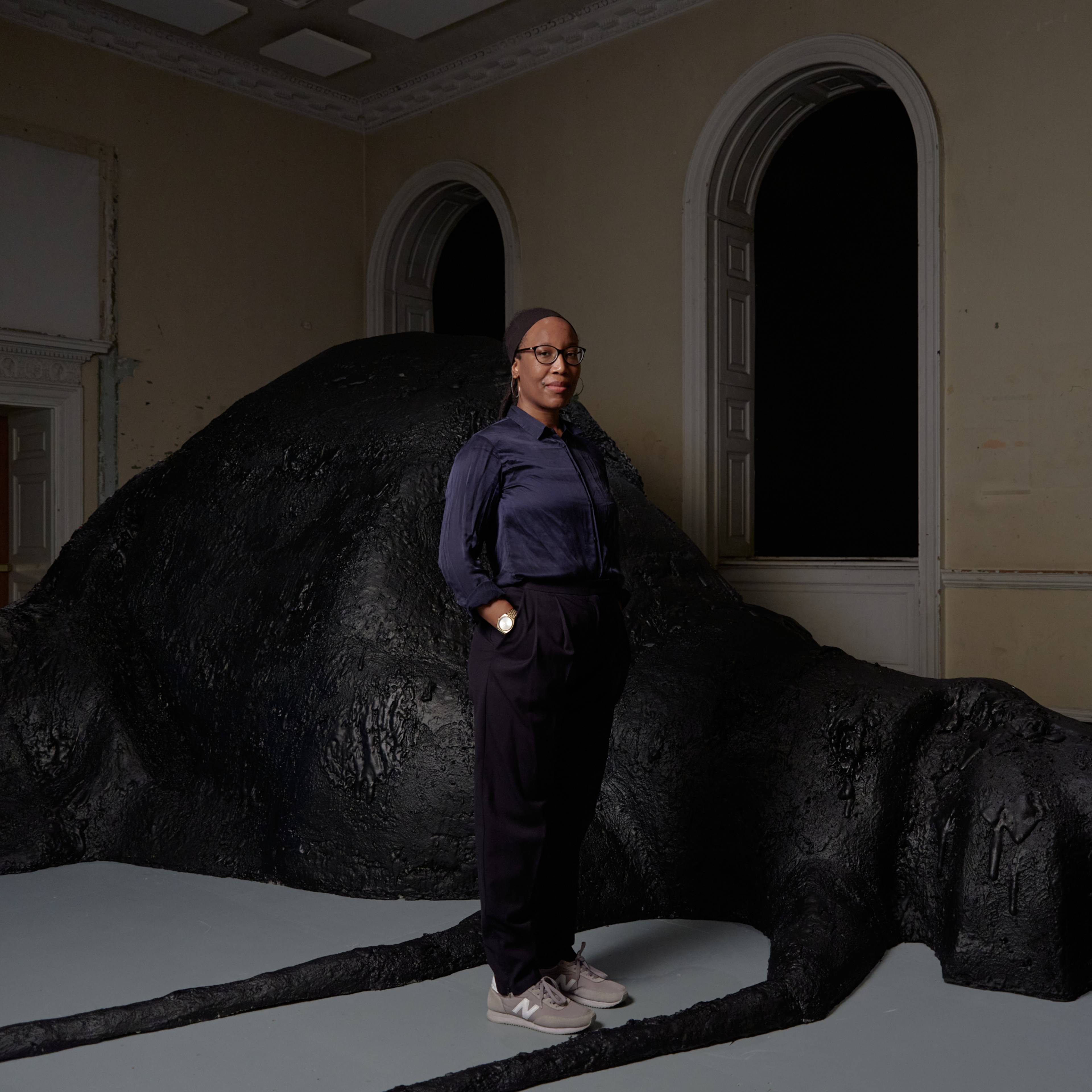 Porträt einer Frau vor einer großen Bodenskulptur