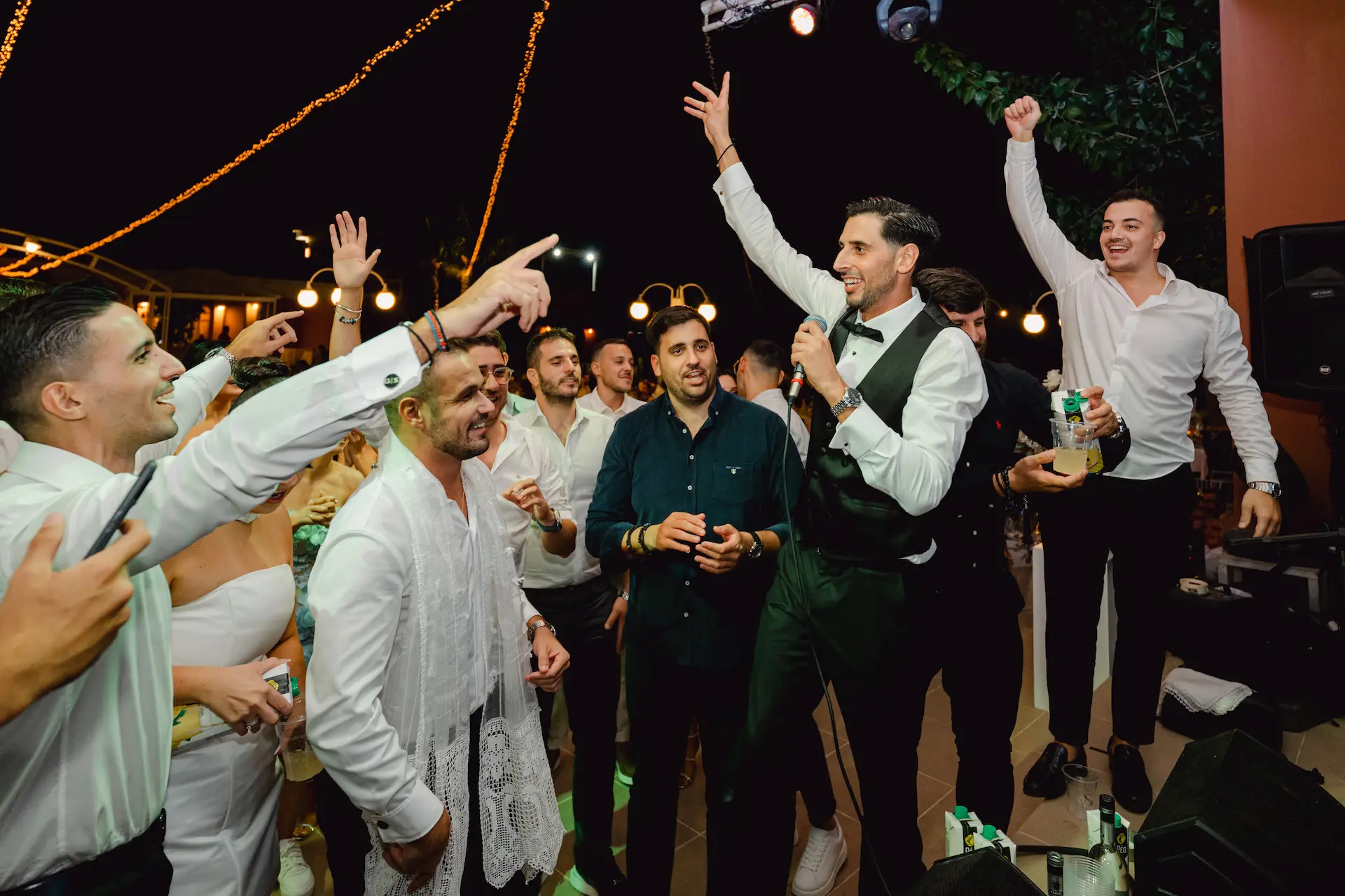 groom singing traditional songs in the microphone and their friends cheer him up