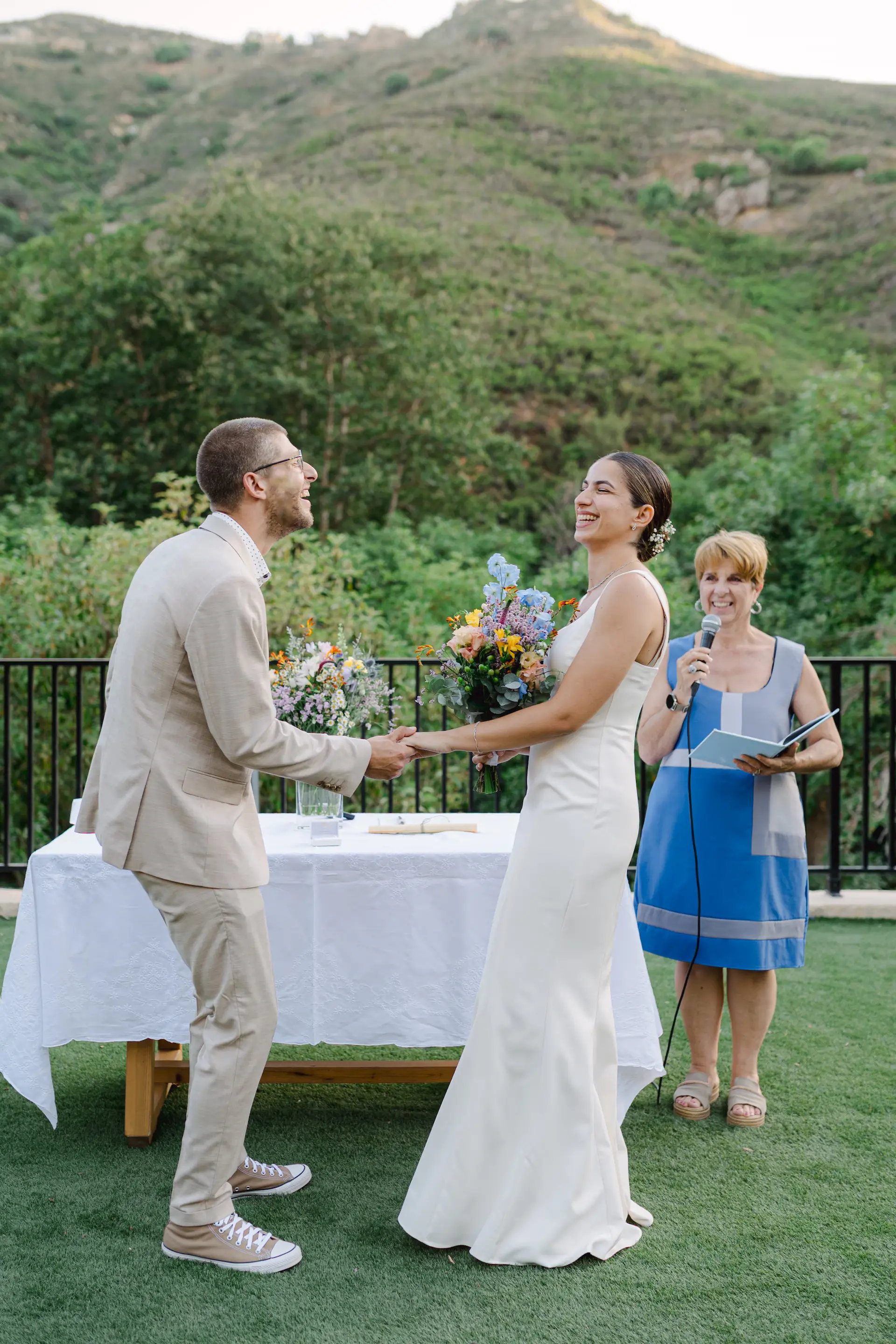 bride and groom holding hands and laughing during wedding ceremony